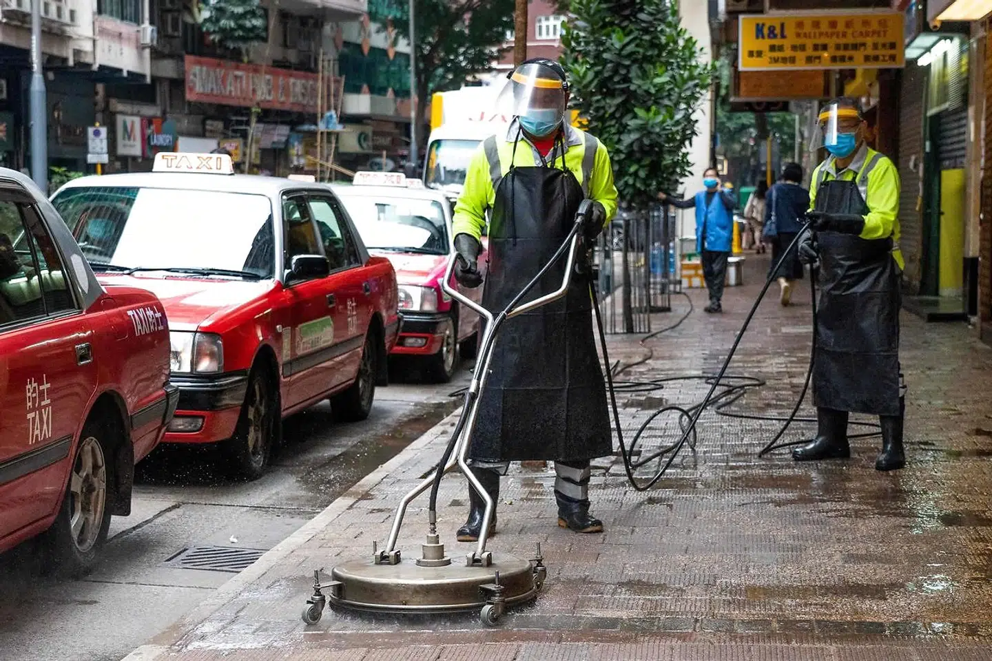 Arbejdere gør rent på gaden i Hongkong.