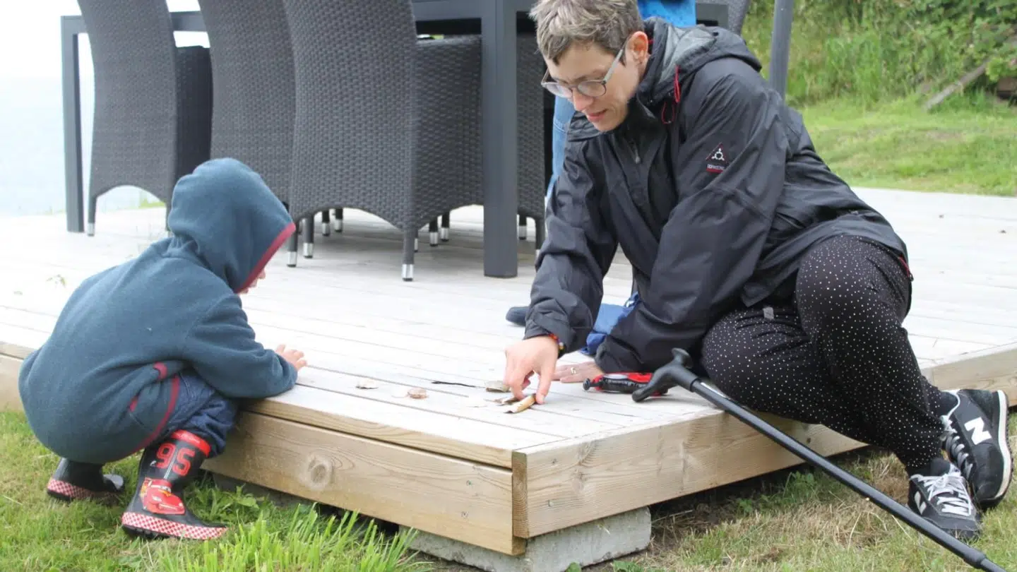 Et foto fra sommerferien 2014, hvor Britt har parkeret rollatoren og går med stok.