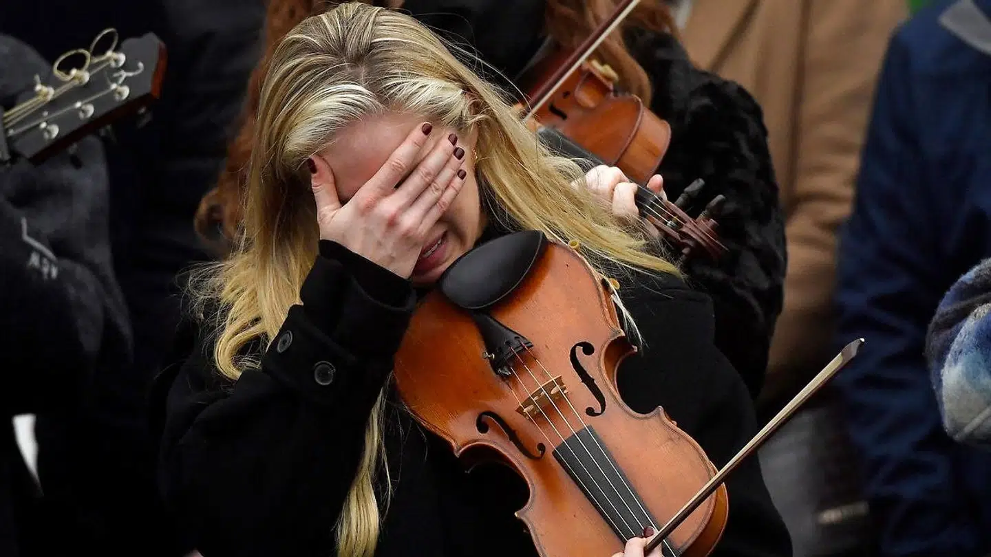 En musiker reagerer under begravelsen af 23-årige Ashling Murphy.
