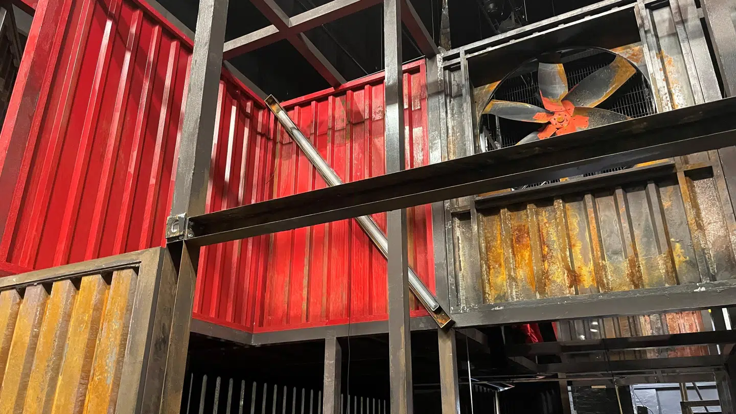 Scenografien består af store containere, der er stablet oven på hinanden.