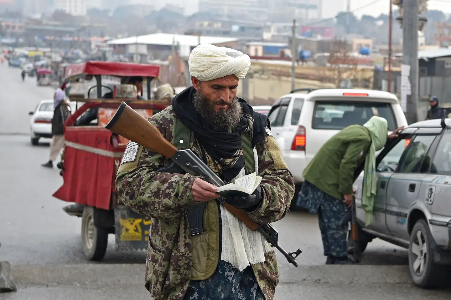 En talibaner tjekker en bilists dokumenter i Afghanistans hovedstad, Kabul. Siden den militante gruppe kom til magten i august, har den nedlagt tre ministerier og nu også landets valgkommission. (Arkivfoto) Wakil Kohsar/Ritzau Scanpix