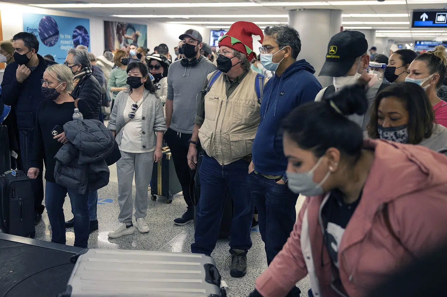 Juledagene er travle rejsedage - også her i Miami lufthavn. Omkring 109 millioner amerikanere ventes at rejse for at være sammen med familie i julen. Men coronasmitte og dårligt vejr har tvunget flyselskaber til at aflyse mange afgange fredag. Joe Raedle/Ritzau Scanpix