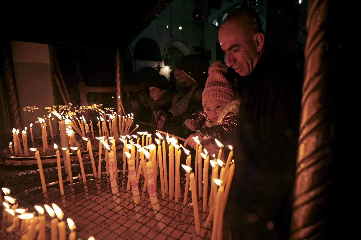 Besøgende tænder lys i Fødselskirken, der menes at være det sted, hvor Jesus blev født, juleaftensdag i Betlehem på den besatte Vestbredden. Abbas Momani/Ritzau Scanpix