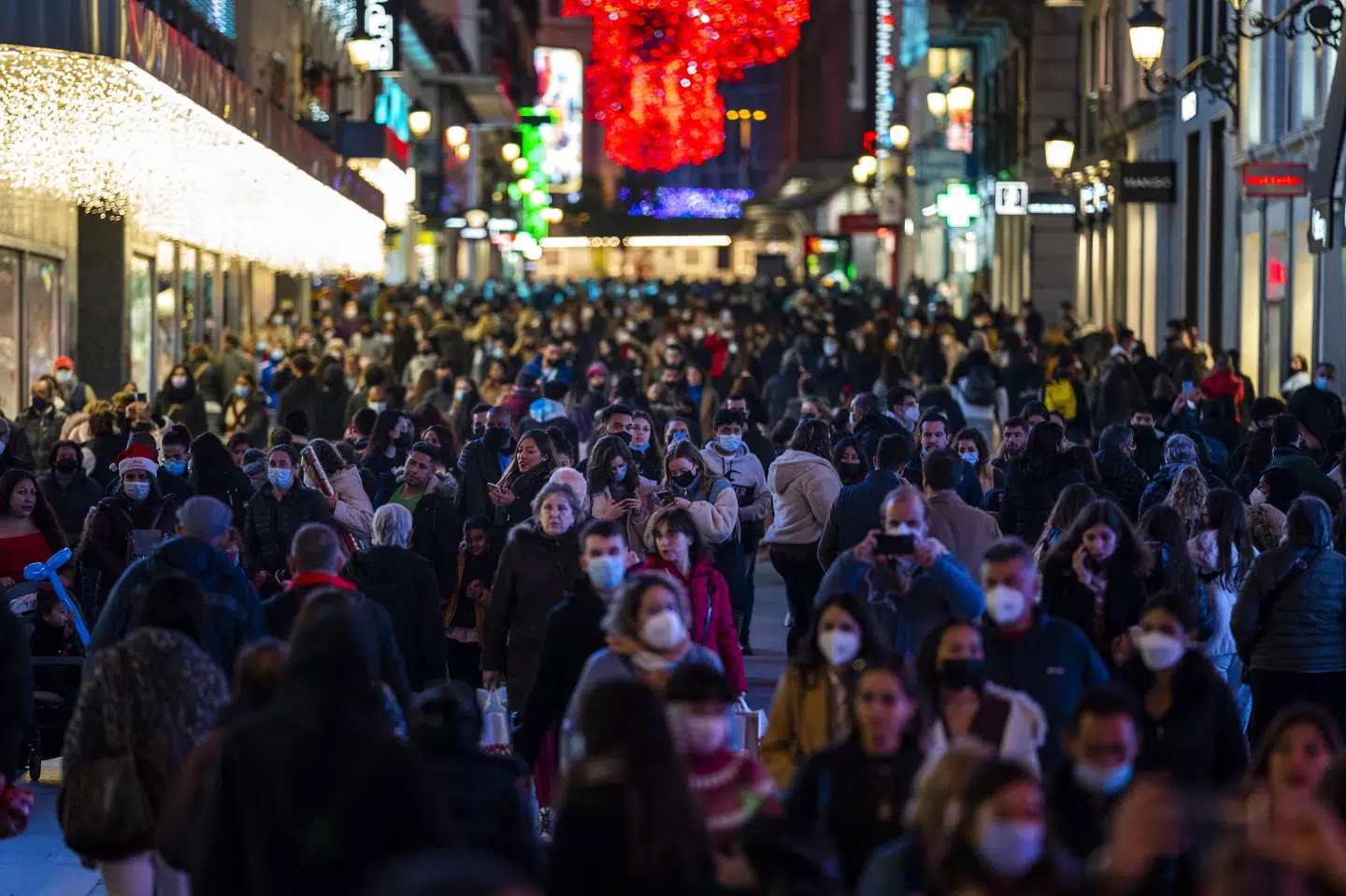 Flere kunne ses bære mundbind, da tusindvis af mennesker tirsdag var ude for at juleshoppe i centrum af Madrid. Bernat Armangue/Ritzau Scanpix