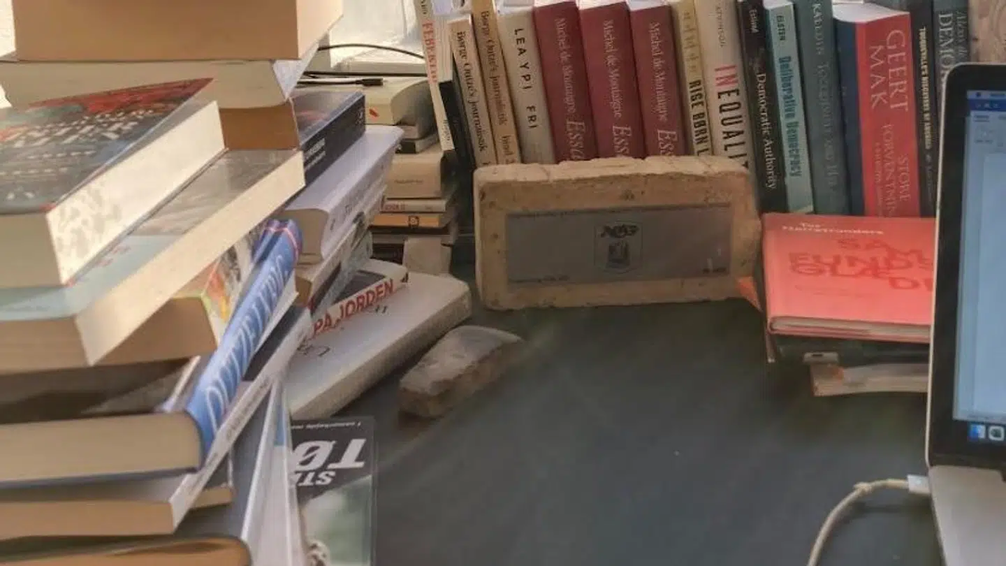 Murstenen fra AGFs gamle klubhus, som Rune Lykkeberg fik af sin kone i julegave. Stig Tøftings selvbiografi 'No Regrets' ses også i bunken af bøger.