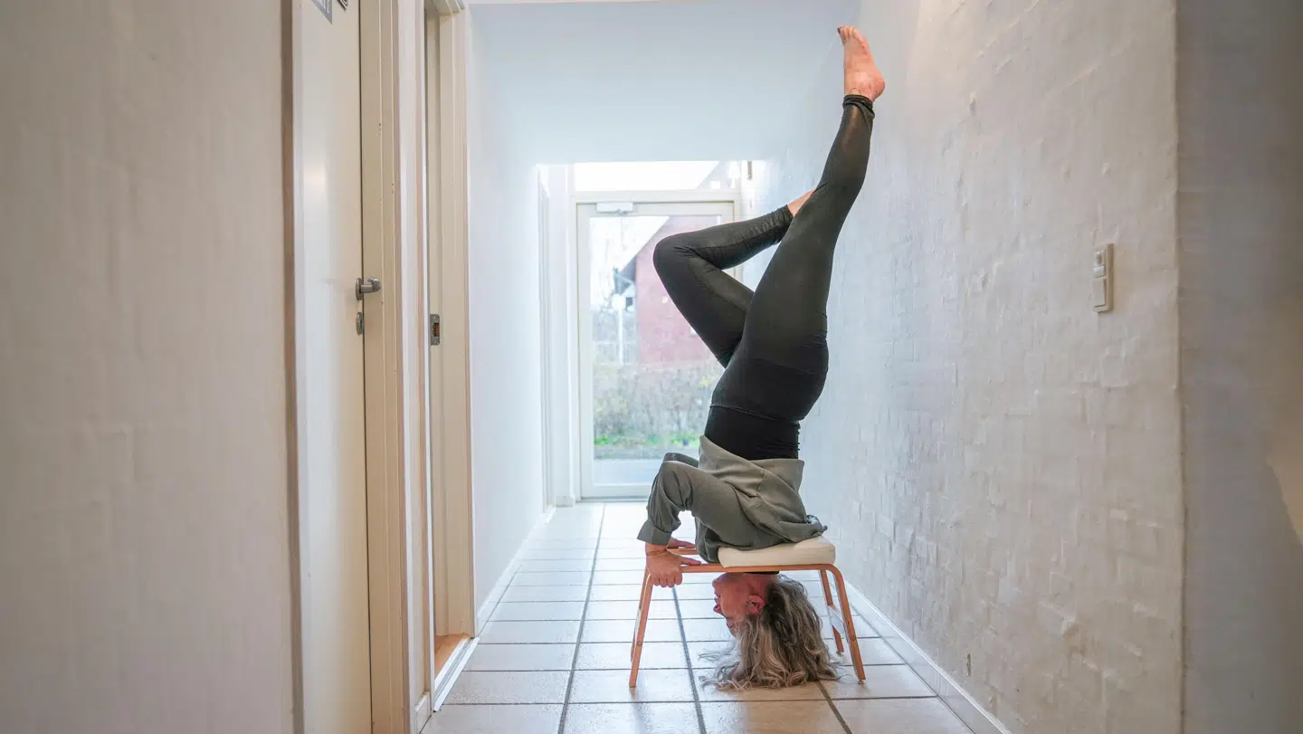 Tine Bay kan ikke stå i planke på grund af sår på fødderne. Til gengæld kan hun stå på hovedet, så det gør hun ti minutter hver dag.