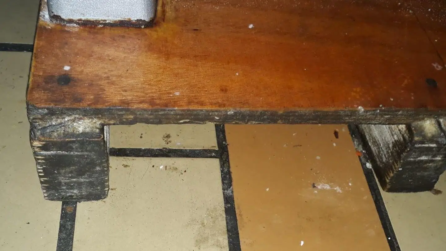 Billede af en slidt, ubehandlet træplade under en røremaskine i køkkenet. Foto: Fødevarestyrelsen