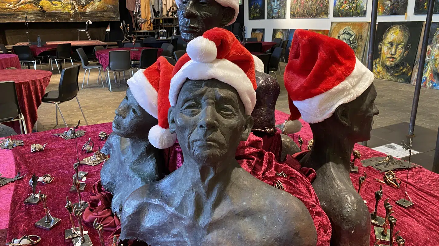 I udstillingen på værkstedet har værker af flygtninge fået nisserhuer på i anledning af julemåneden. Ved siden af står fuckfingre i bronze, som bliver solgt som julegaver.