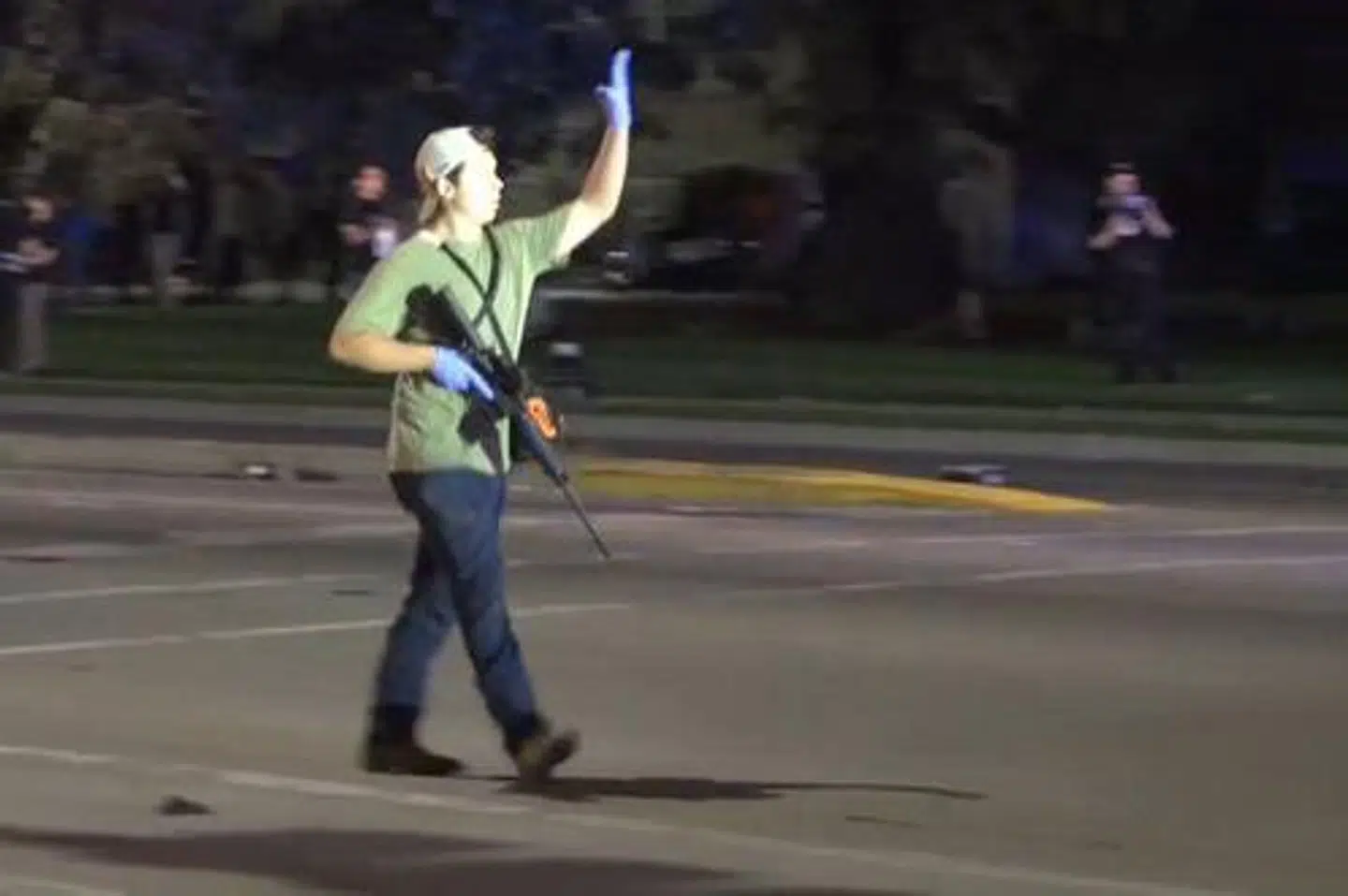 Kyle Ritterhouse på gaden i Kenosha, hvor han skød tre og dræbte to mennesker. Her vinker han til politiet.