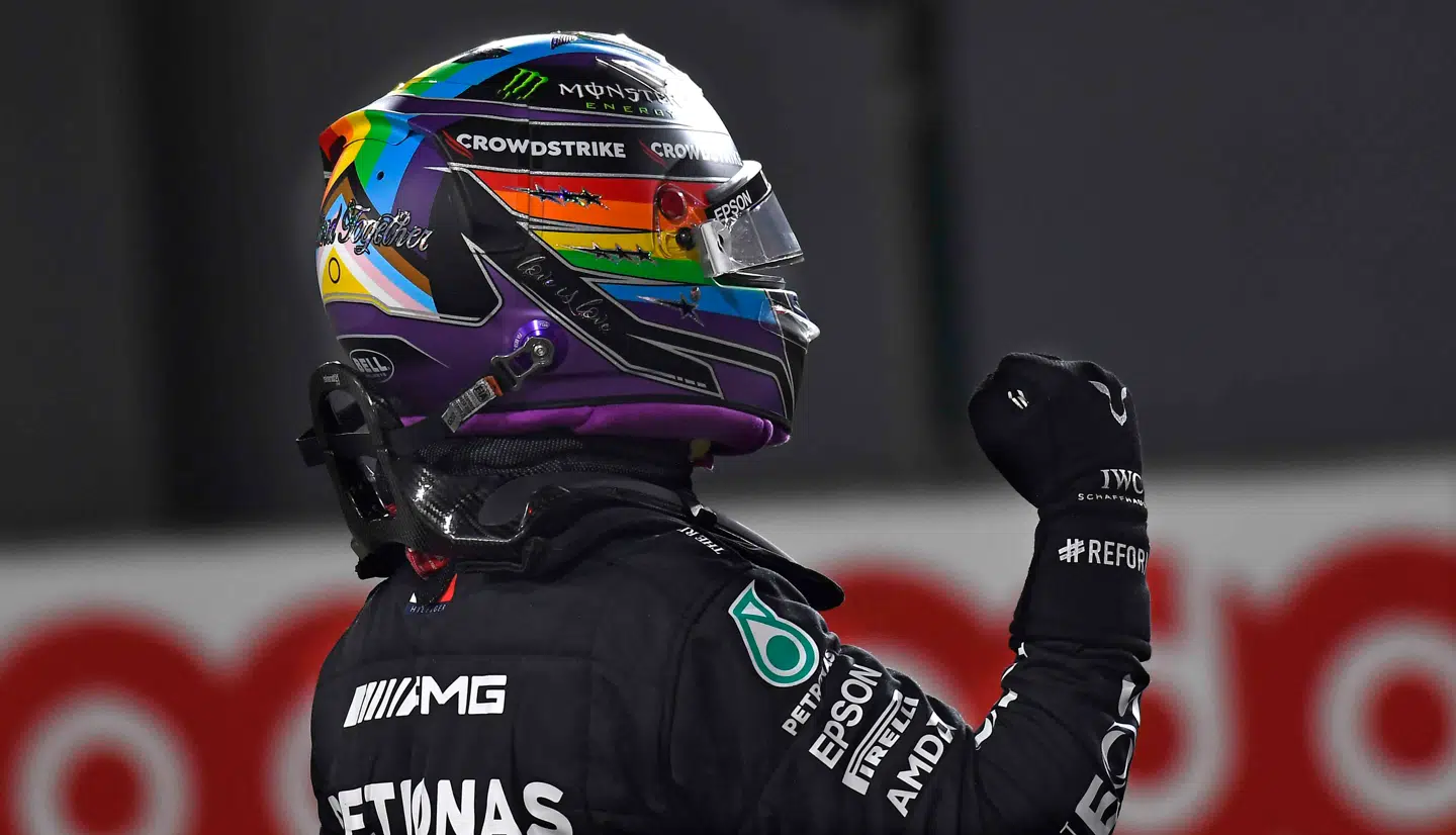 Lewis Hamilton - med regnbue-farvet hjelm til støtte for LBGT+-miljøet - fejrer sin pole position i Qatar.