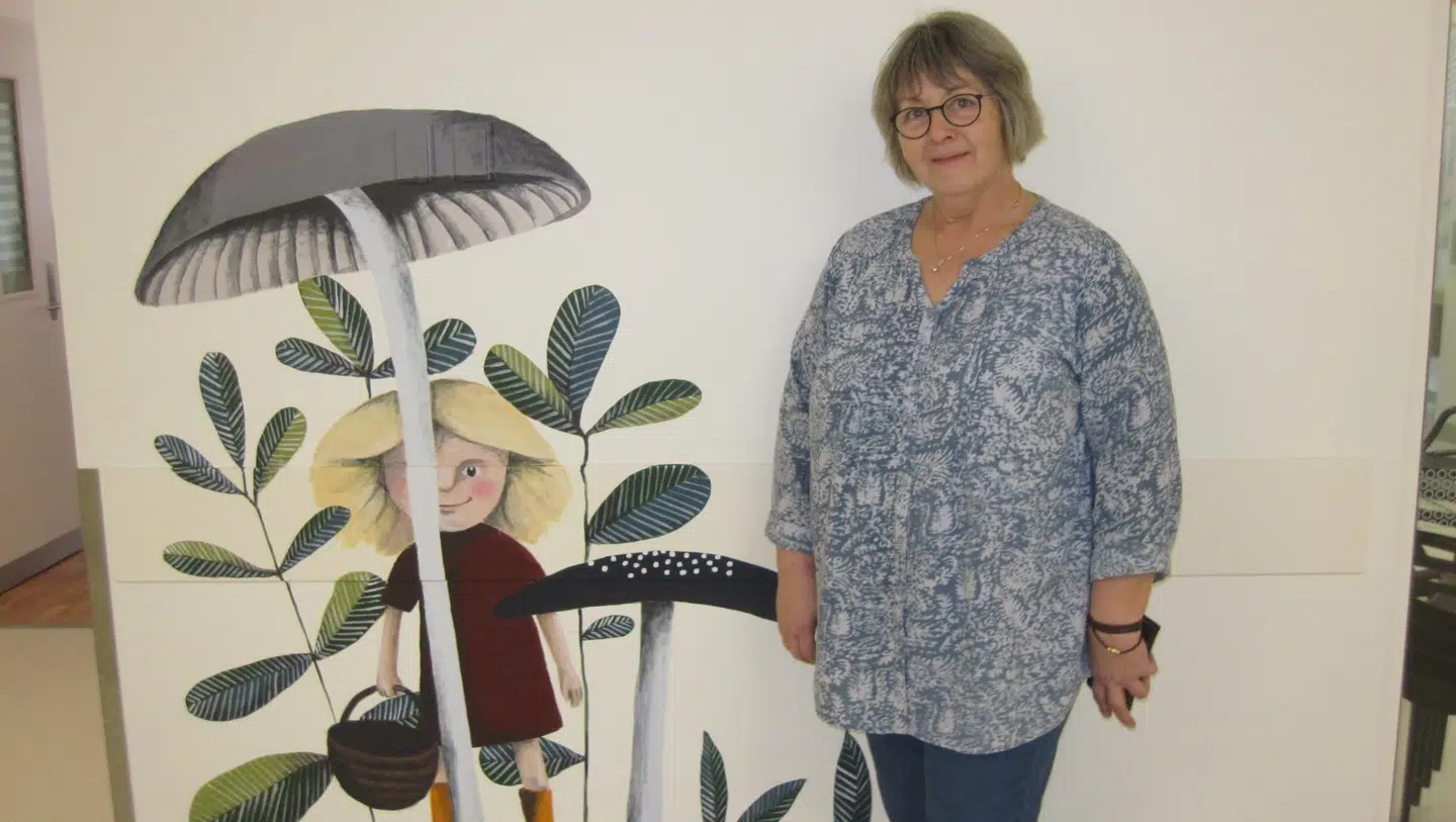 Karen Søndergaard foran et af de vægmalerier, deres donation har været med til at sponsorere. De har også været med til at donere Virtual Reality briller, der gør, at børn kan leve sin ind i en anden verden, når de skal undersøges.