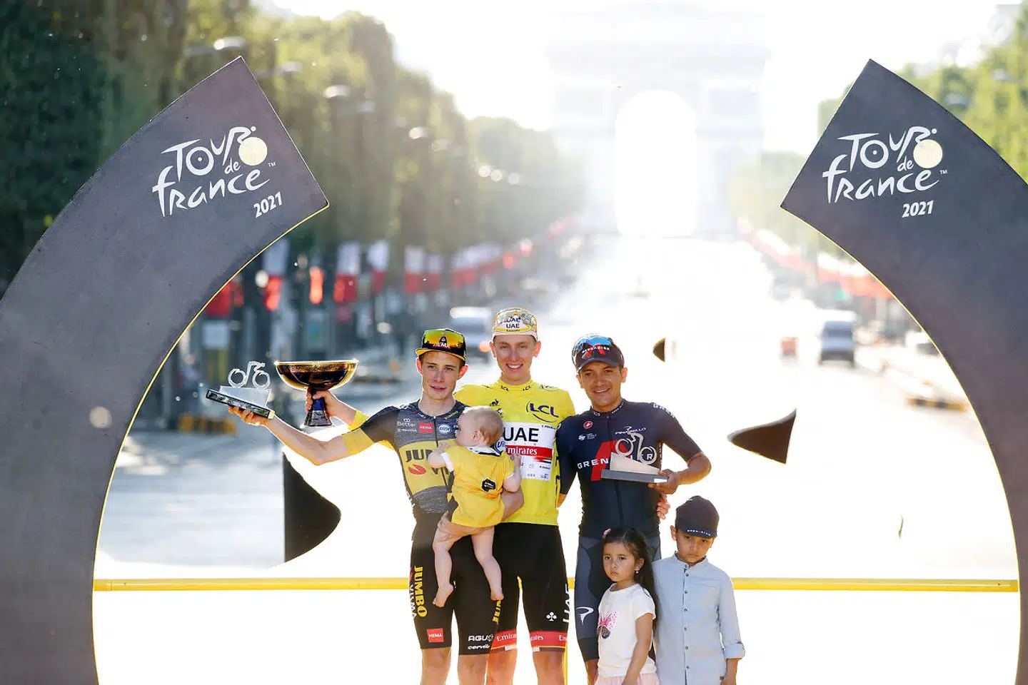 Jonas Vingegaard (yderst tv.) med datteren Frida på Tour de France-podiet i Paris. Han blev nummer to efter Tadej Pogacar, men foran Richard Carapaz.