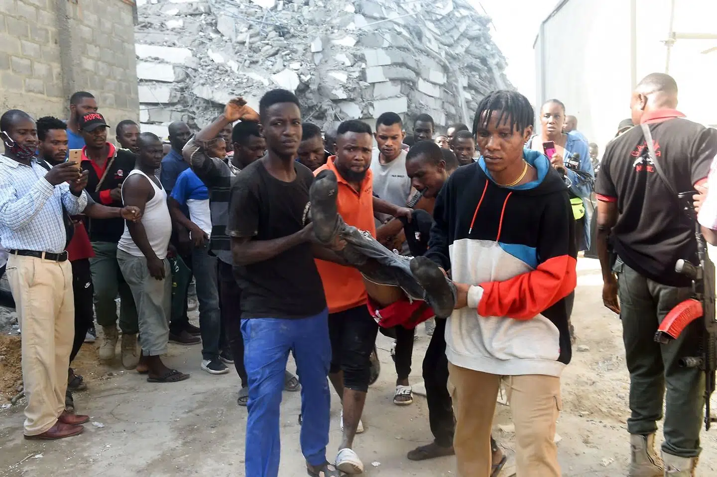 EDITORS NOTE: Graphic content / TOPSHOT - A deceased worker is pulled out from the rubble of a 21-storey building under construction that collapsed at Ikoyi district of Lagos, on November 1, 2021. - Several people have been trapped while unspecified number of people mostly construction workers were feared dead as a 21-storey building suddenly collapsed in the Ikoyi district of Lagos, Nigeria's commercial capital. (Photo by PIUS UTOMI EKPEI / AFP)