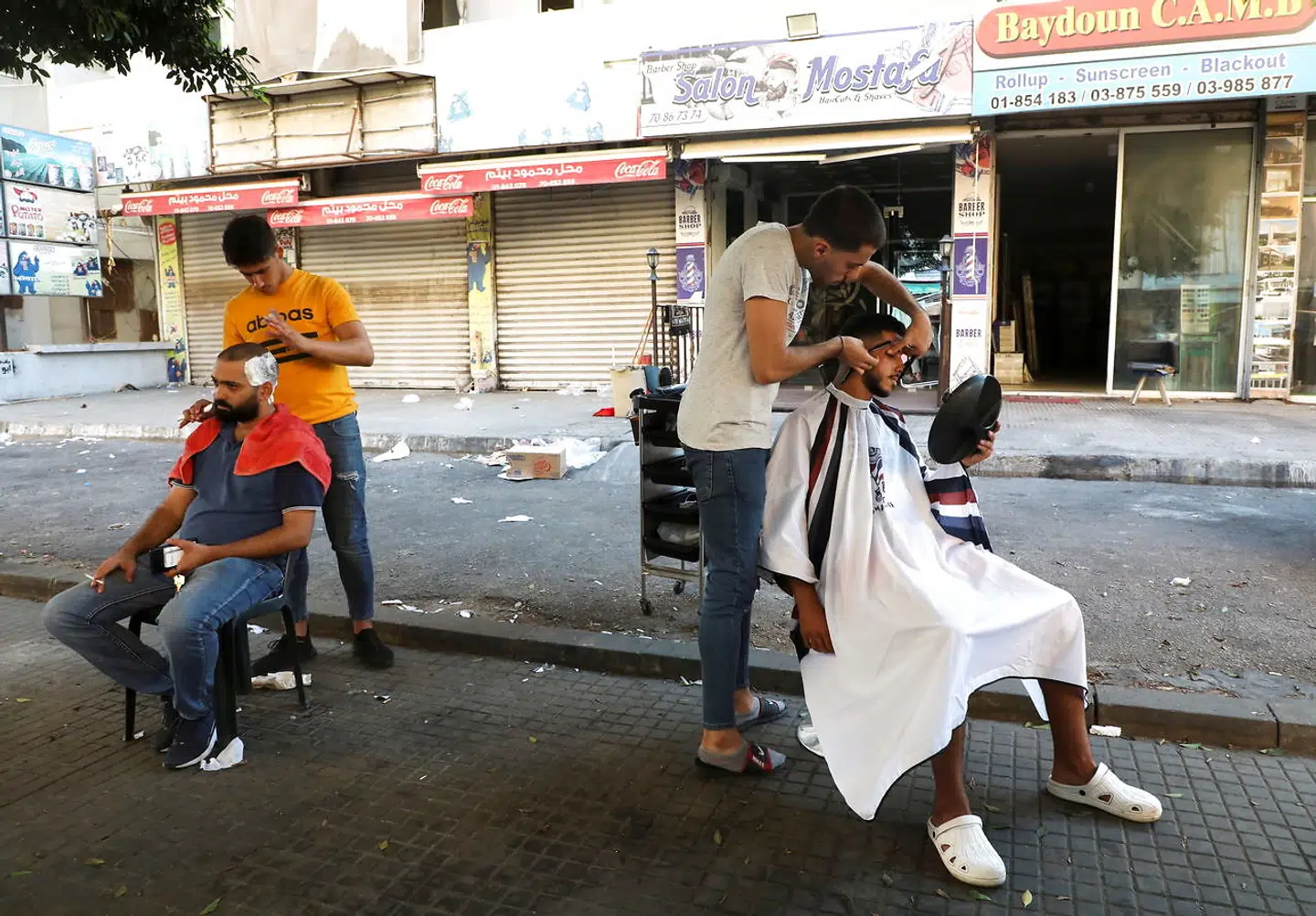 Barberer i Beirut søger ud på gaden for at barbere kunderne. Der er ingen strøm i Libanon på grund af energikrisen.