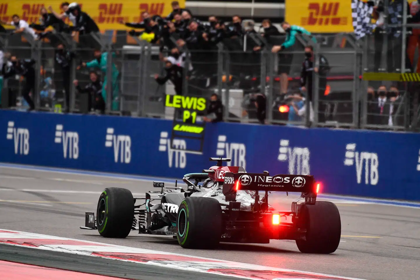 Lewis Hamilton krydser målstregen foran Mercedes-mekanikerne.