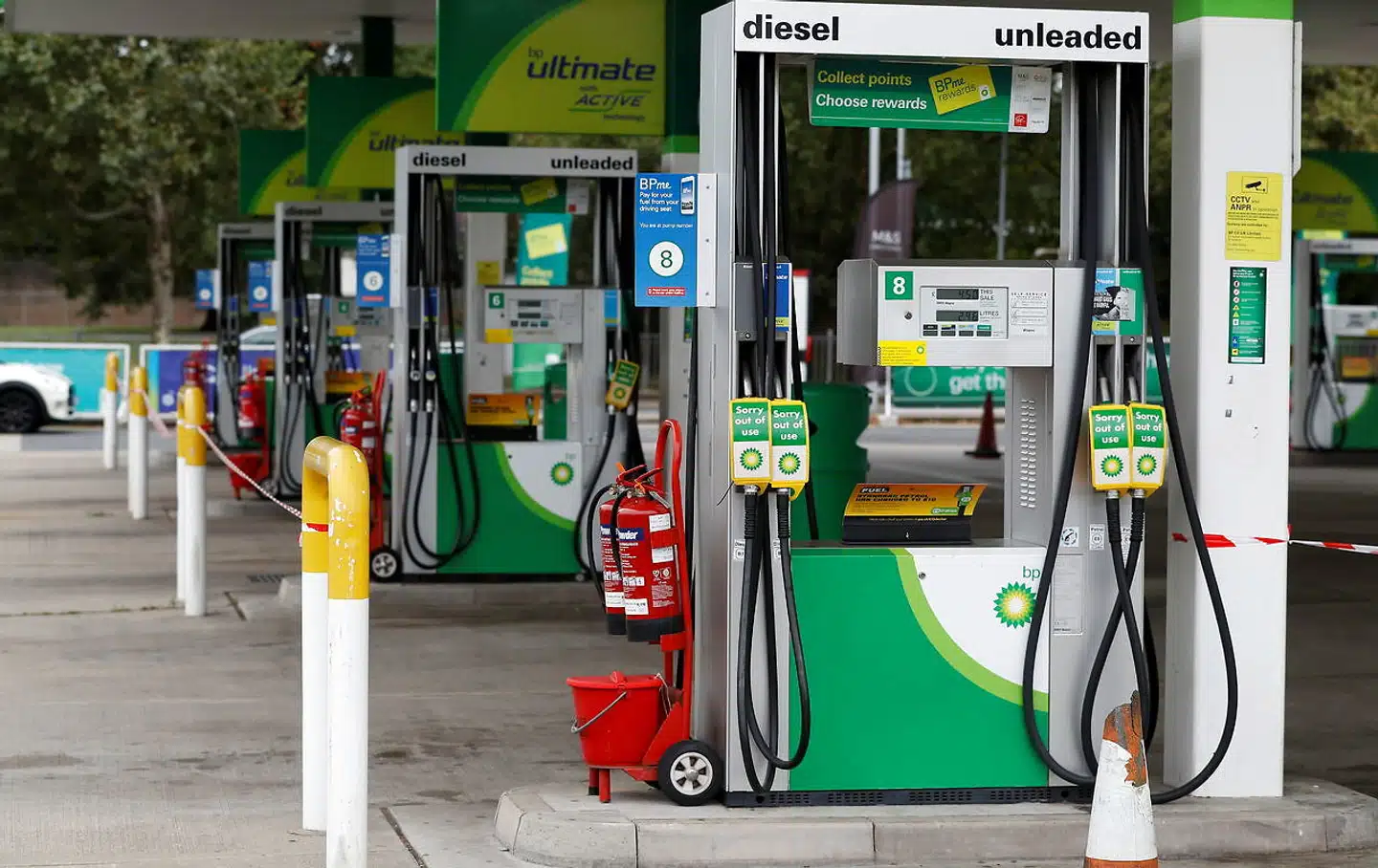 Der hænger skilte med 'ude af drift' ved pumperne på en tankstation, der er løbet tør for brændstof.