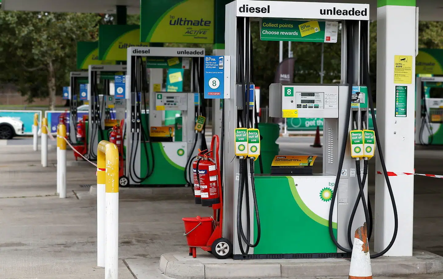 Der hænger skilte med 'ude af drift' ved pumperne på en tankstation, der er løbet tør for brændstof.