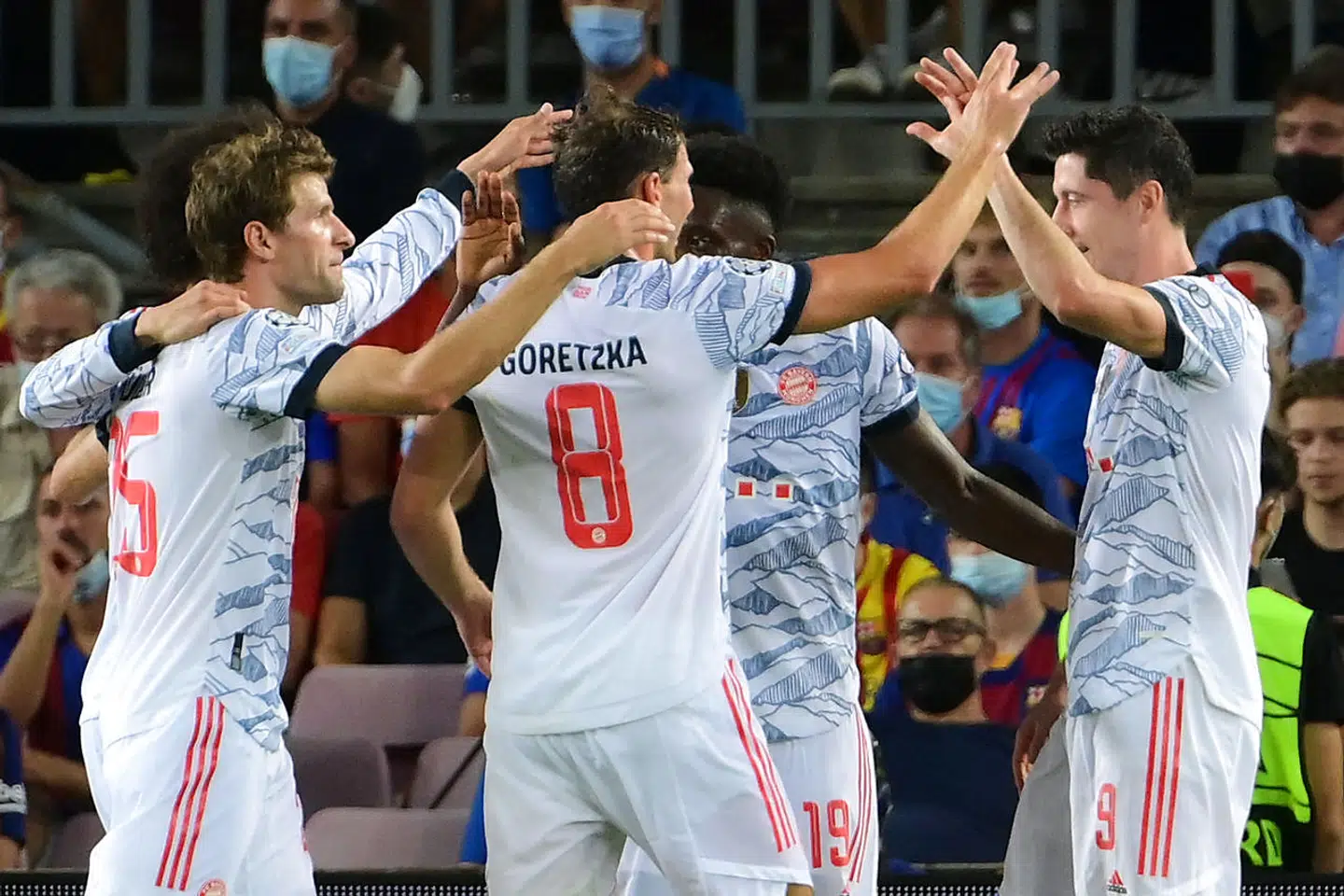 Bayern Munich's Polish forward Robert Lewandowski (R) celebrates his goal with his teammates during the UEFA Champions League first round group E football match between Barcelona and Bayern Munich at the Camp Nou stadium in Barcelona on September 14, 2021. (Photo by LLUIS GENE / AFP)