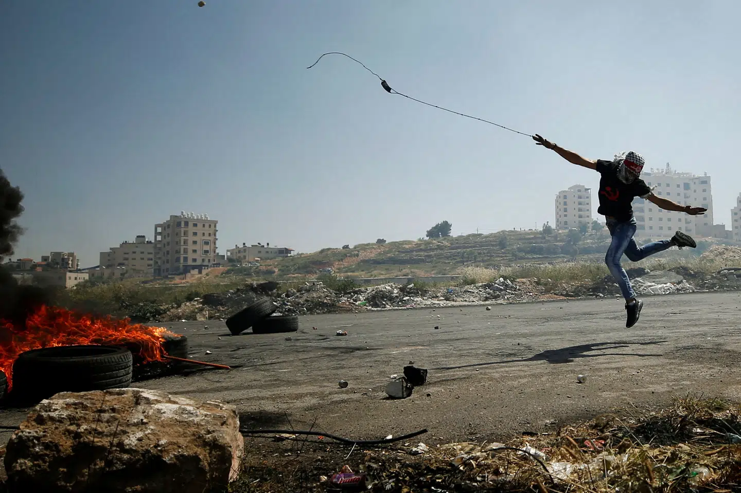 En palæstinenser med stenslynge aktionerer ved israelsk bosættelse nær Ramallah for at vise støtte til palæstinensiske fanger, som vil sultestrejke i protest mod deres forhold.