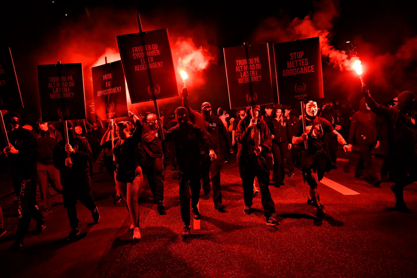Sortklædte demonstranter med nødblus til Men in Black-demonstration i København.