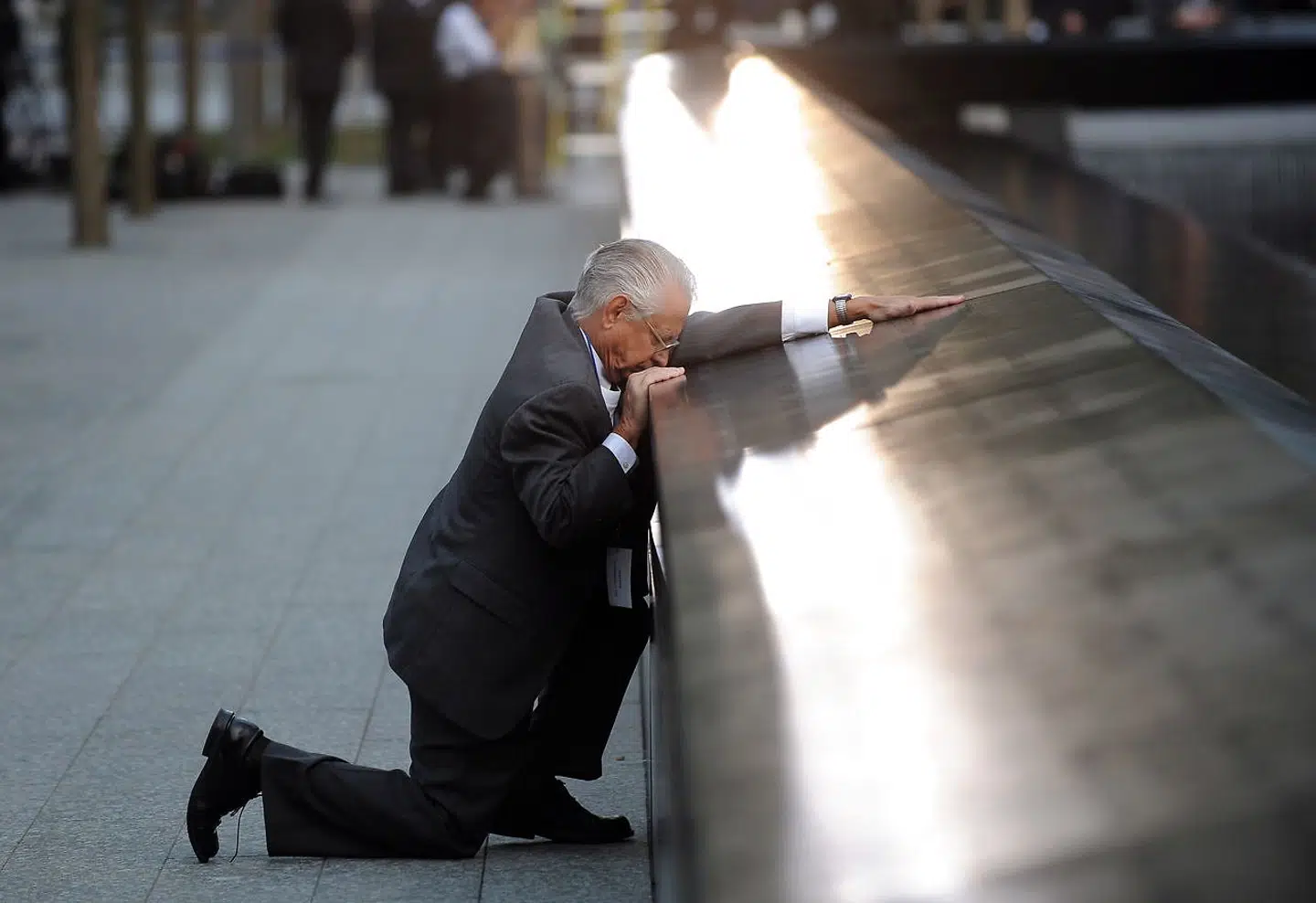 Robert Peraza knæler ved sin søns navn 9/11 Memorial.