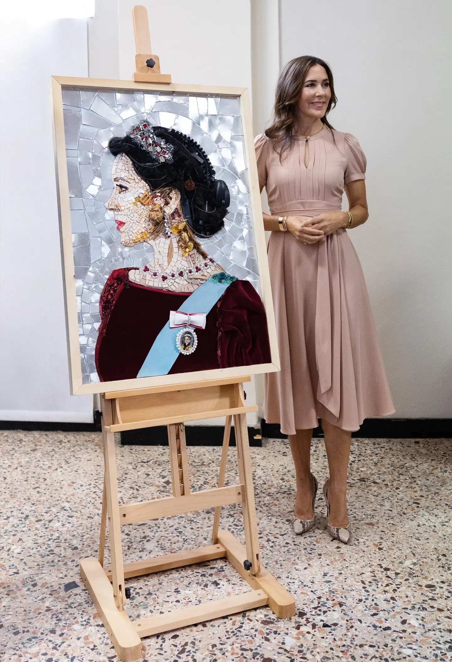 Her kan du se kronprinsesse Mary med et portræt af hende selv, der er blevet præsenteret under hendes tur i Milano.