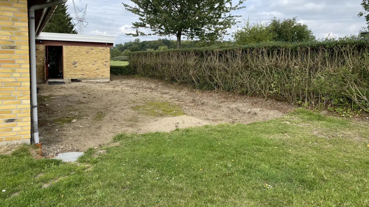 Familien Bechgren har gravet ud til terrasse på bagsiden af huset. Den skal suppleres af noget støjafskærmning ved hækken.