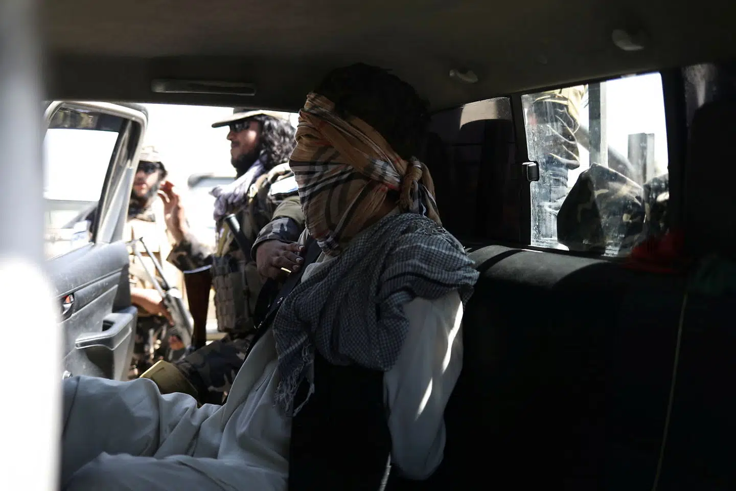 En mistænkt medlem af Isis sidder med bind for øjnene bag i en bil fra Taliban.