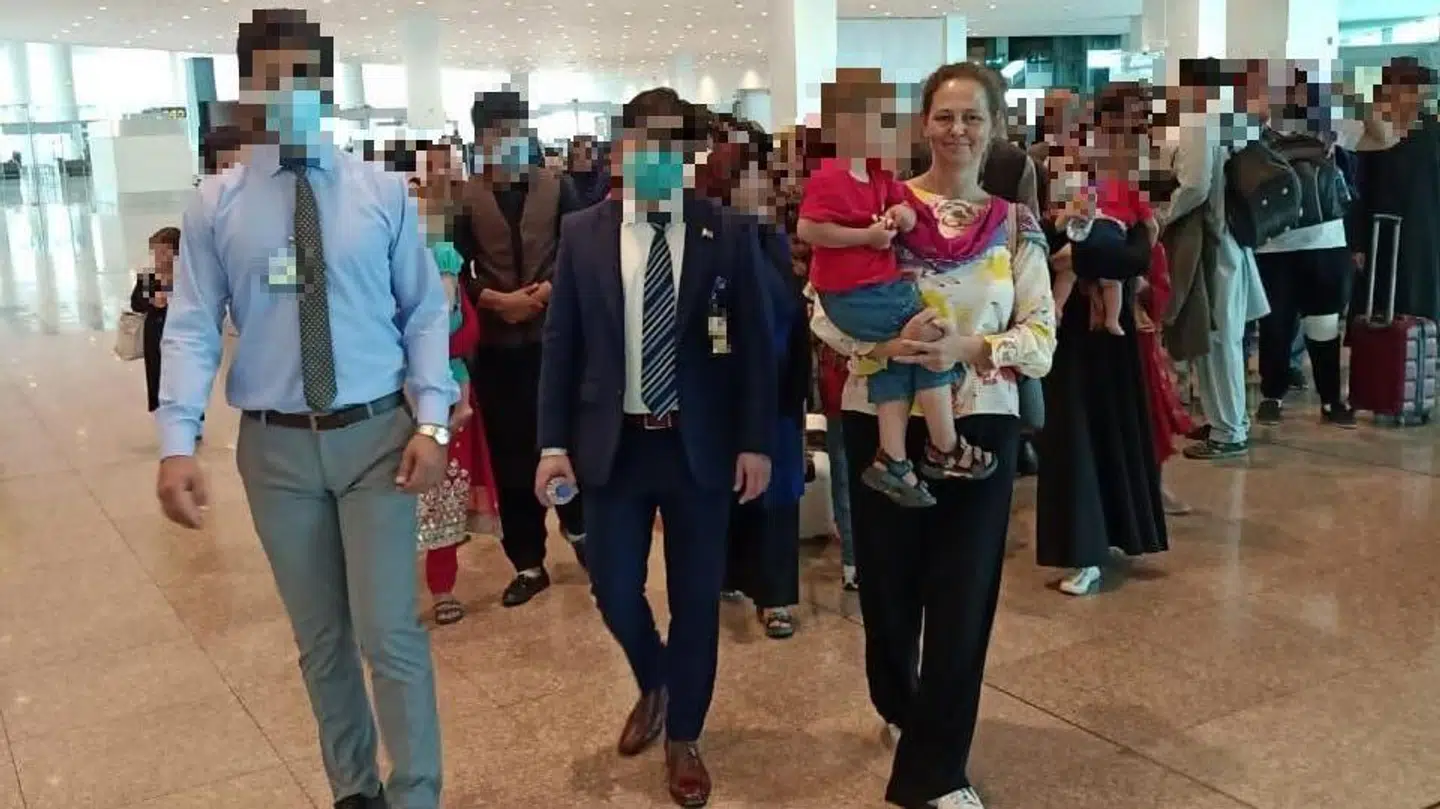 Ambassadør Lis Rosenholm tager et barn, der netop er ankommet fra Kabul, på armen. »Han ville bare have en cola lige nu«, siger ambassadøren.