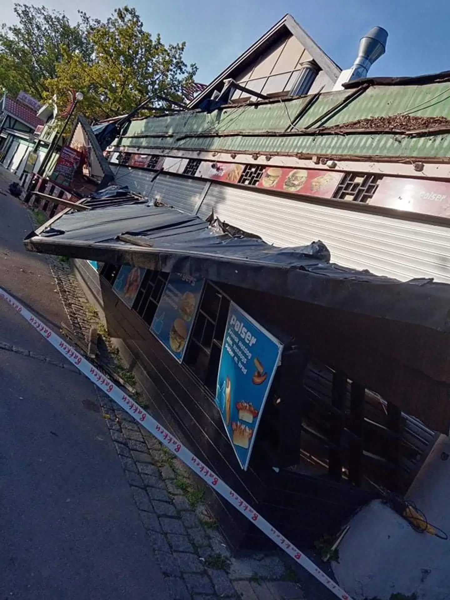 Her ses det, at facaden ligger ned over restaurantens borde og stole.