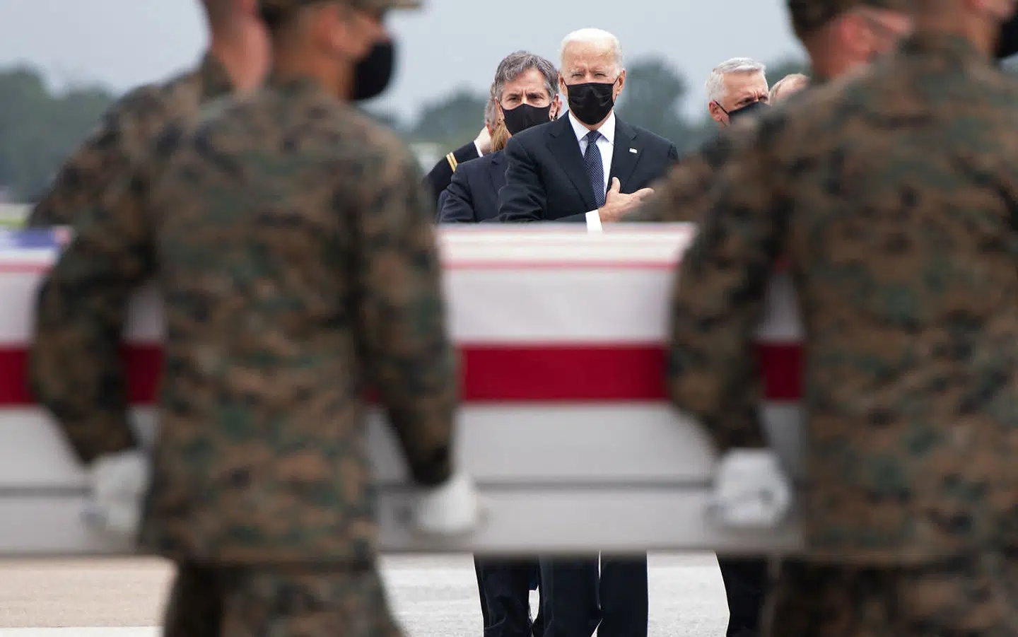 En af kisterne bæres ud fra flyet, der har bragt de 13 døde amerikanske soldater hjem fra Afghanistan.