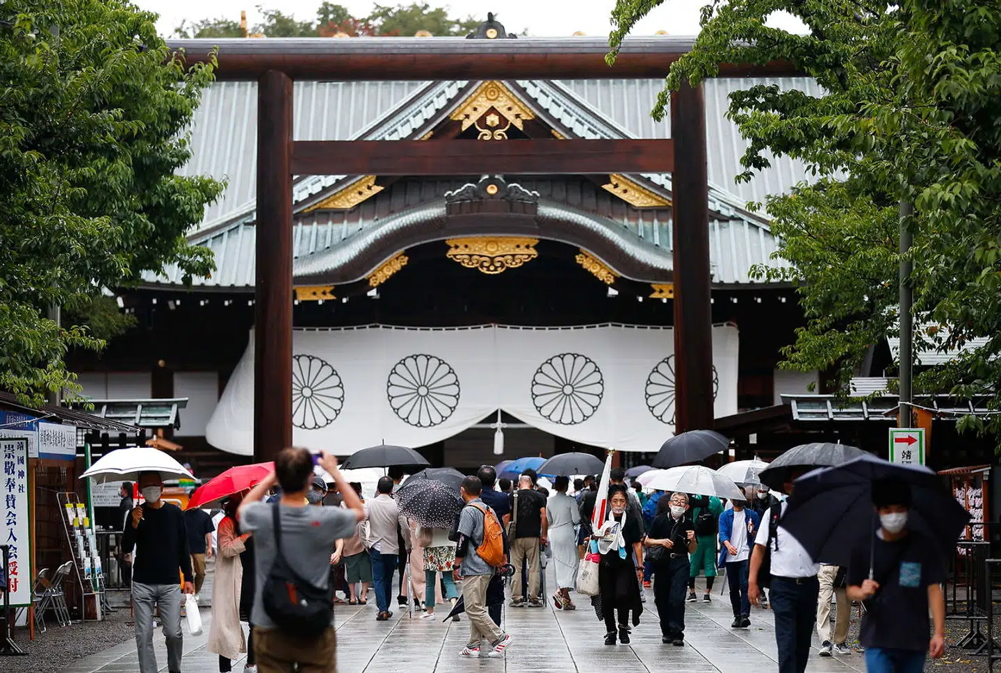 People carry umbrellas as they visit Yasukuni Shrine in Tokyo, Japan August 15, 2021. REUTERS/Issei Kato