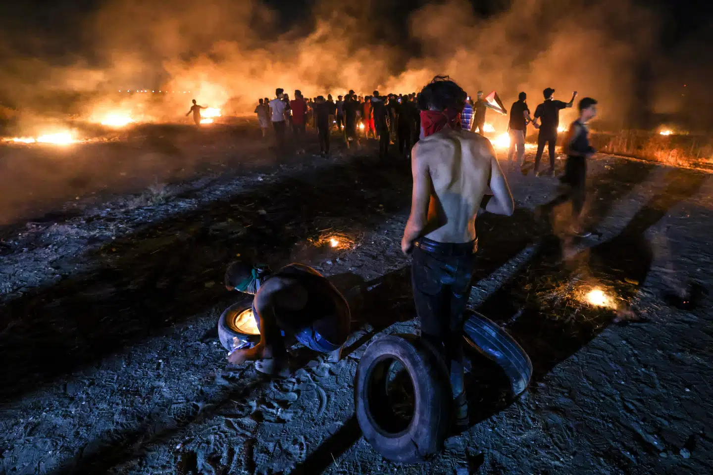 Palæstinensere brændte lørdag aften dæk af under en demonstration nær grænsen mellem Gazastriben og Israel. Mahmud Hams/Ritzau Scanpix