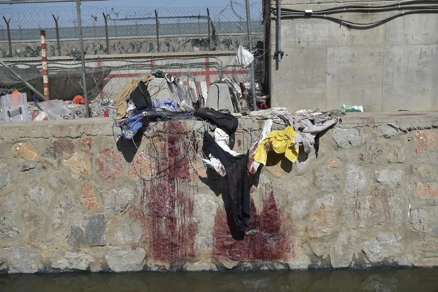 Clothes and blood stains of Afghan people who were waiting to be evacuated are seen at the site of the August 26 twin suicide bombs, which killed scores of people including 13 US troops, at Kabul airport on August 27, 2021. (Photo by WAKIL KOHSAR / AFP)