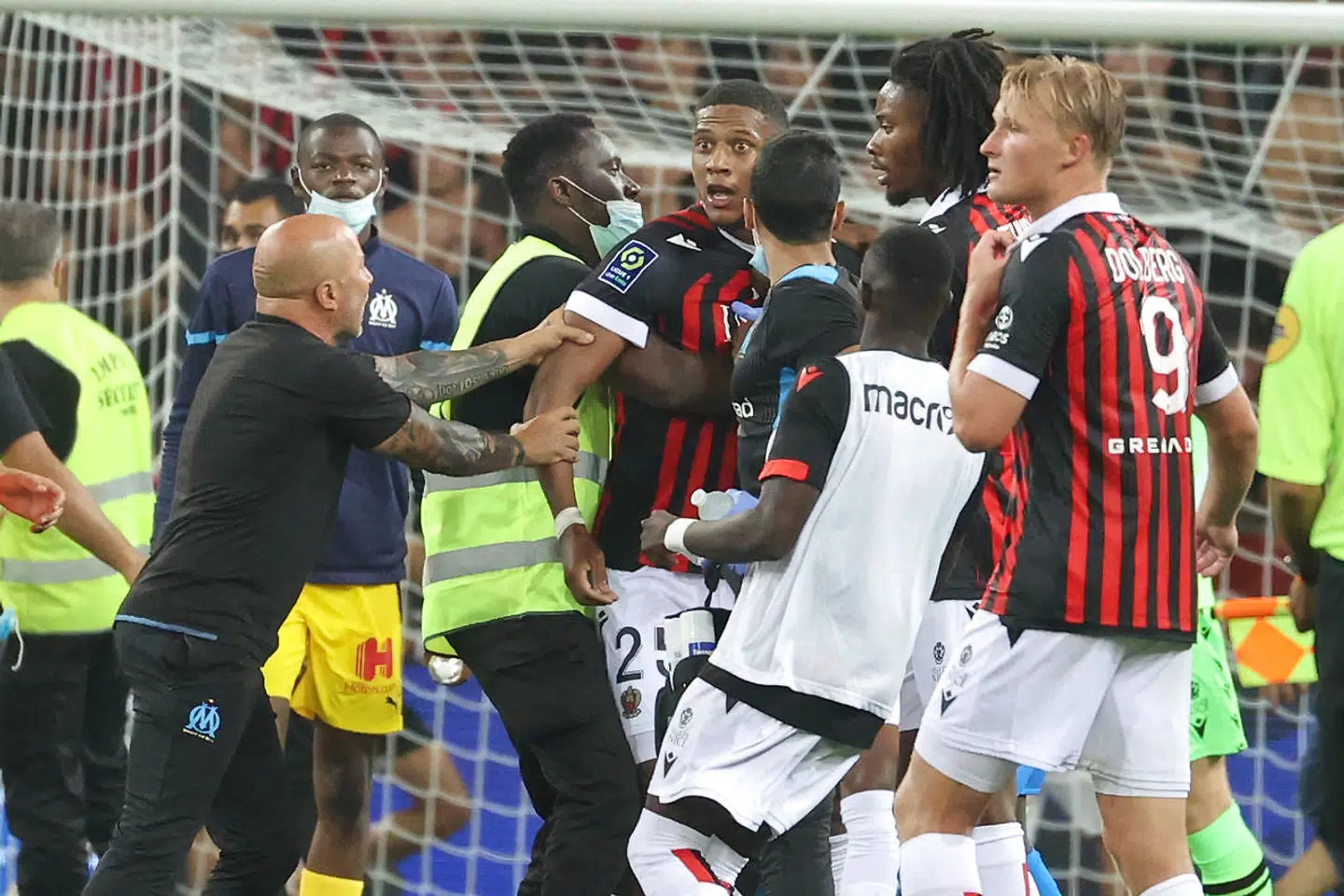 Marseilles cheftræner Jorge Sampaoli hiver fat i en Nice-spiller, mens danske Kasper Dolberg ser på.