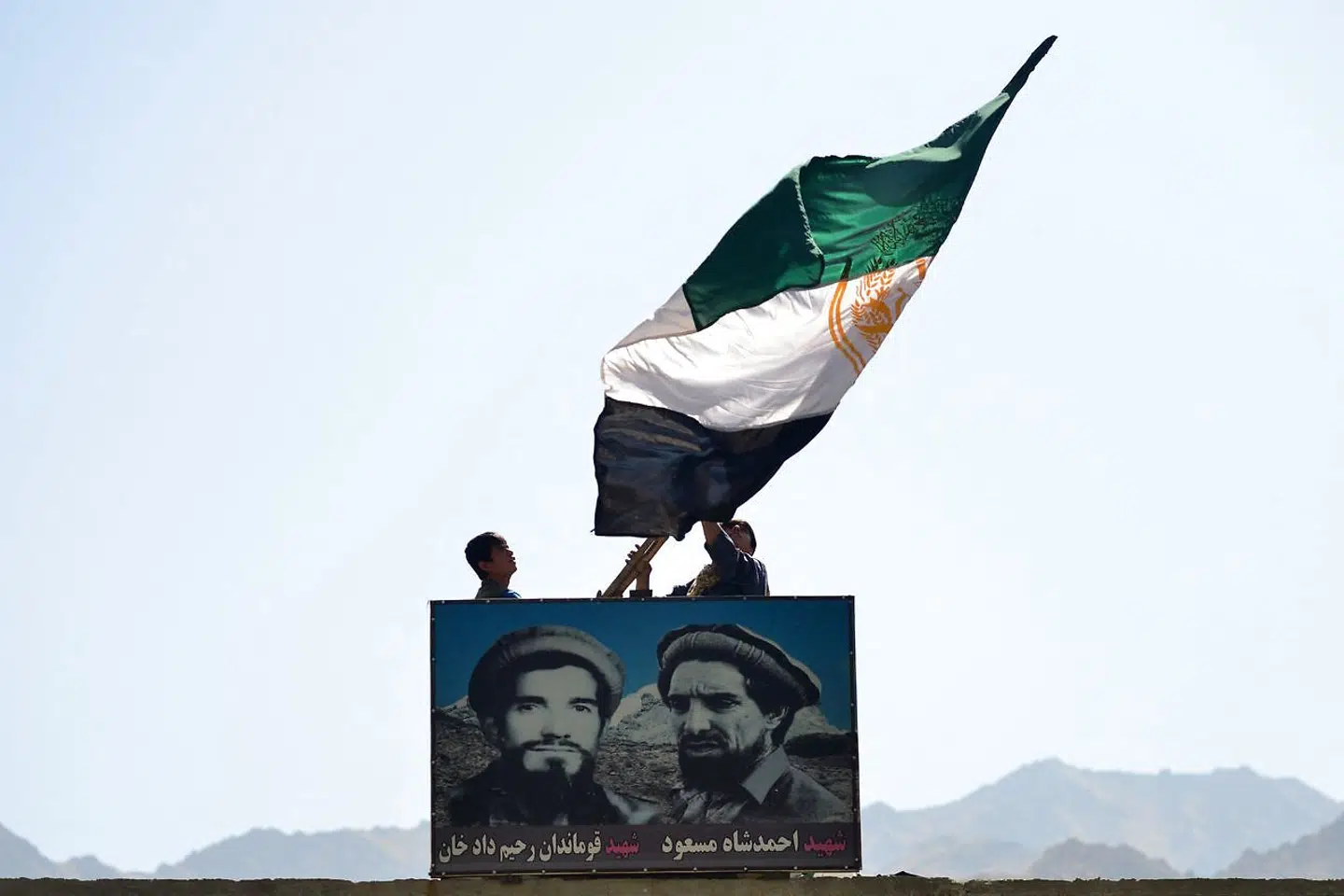 Et flag og et banner forestillende oprørslederen Ahmad Mahmod og hans afdøde far vejrer fra et forsvarspunkt på vej ind i Panjshiredalen.