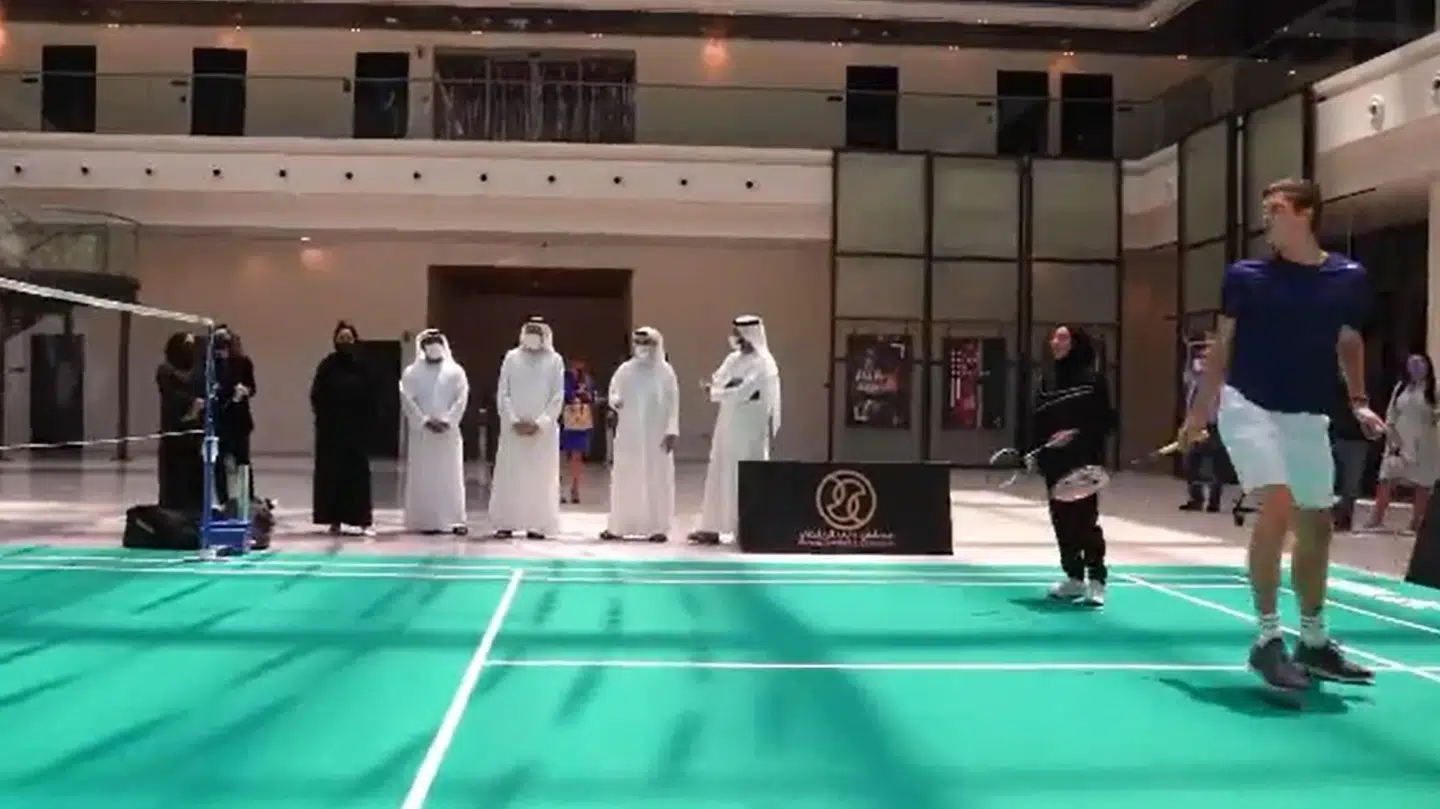 I videoen viser Axelsen sine evner frem, mens repræsentater fra Dubai ser til.