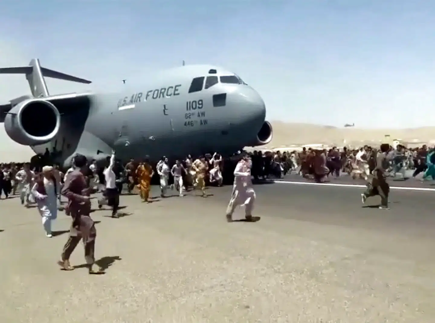 Desperate afghanere forsøgte at komme ombord på et amerikansk militærfly, da det lettede mandag.