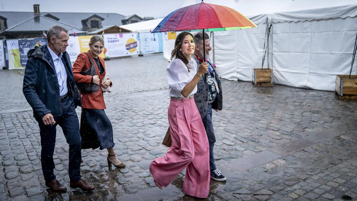 Kronprinsesse Mary måtte søge læ under en regnbueparaply med forpersonen for Copenhagen Pride, Lars Henriksen.
