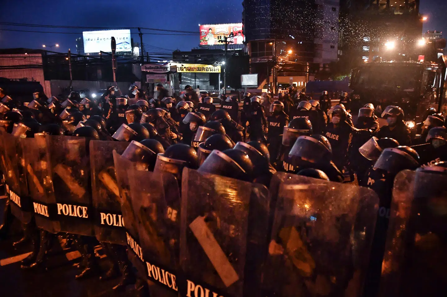 Kampklædte politifolk spærrede en vej af i Bangkok, hvor de stødte sammen med demonstranter fredag. Det er den tredje protest mod regeringen i denne uge.
