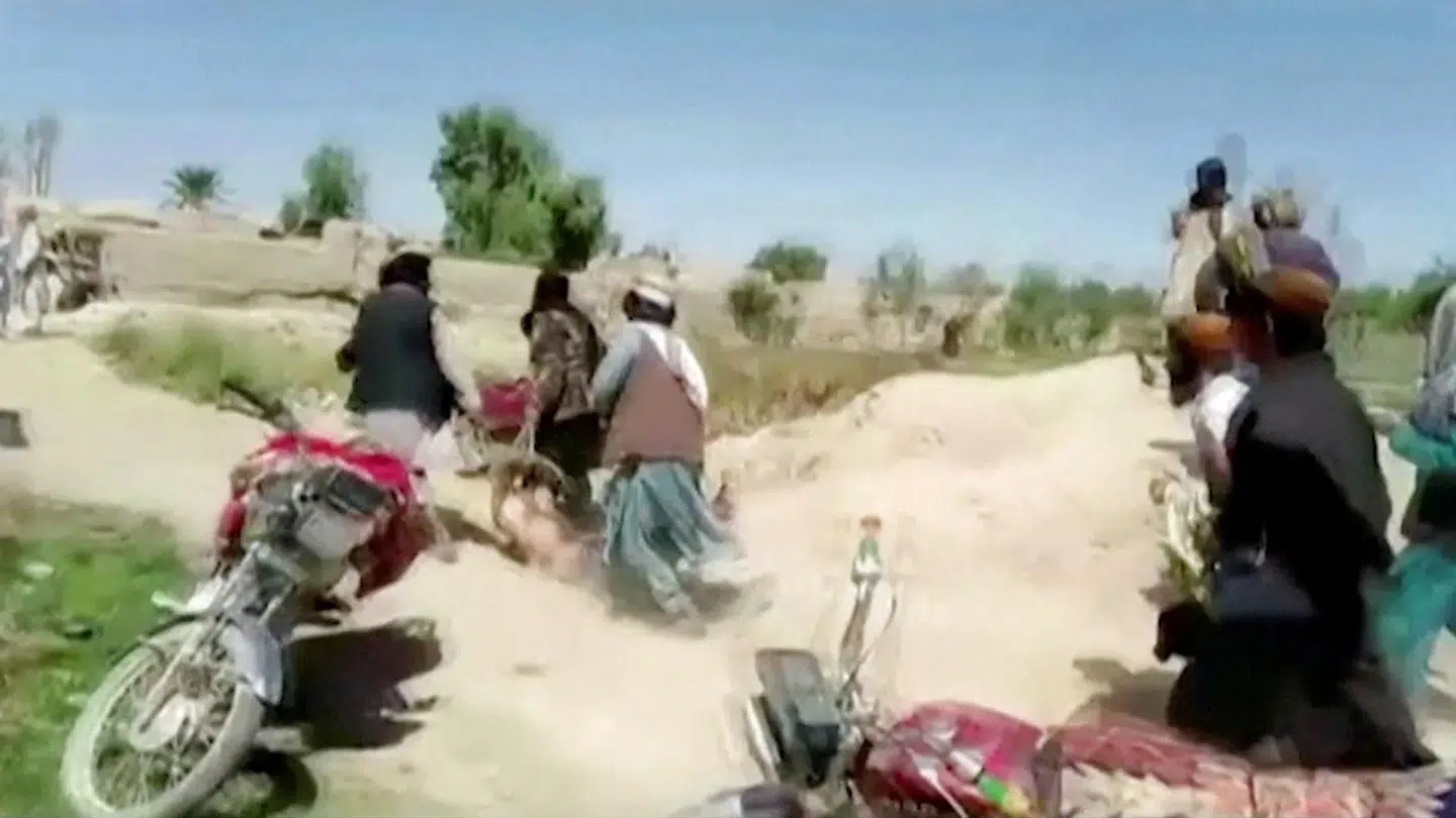 Taleban-krigere slæber en krop væk efter hårde kampe i Farah-provinsen.