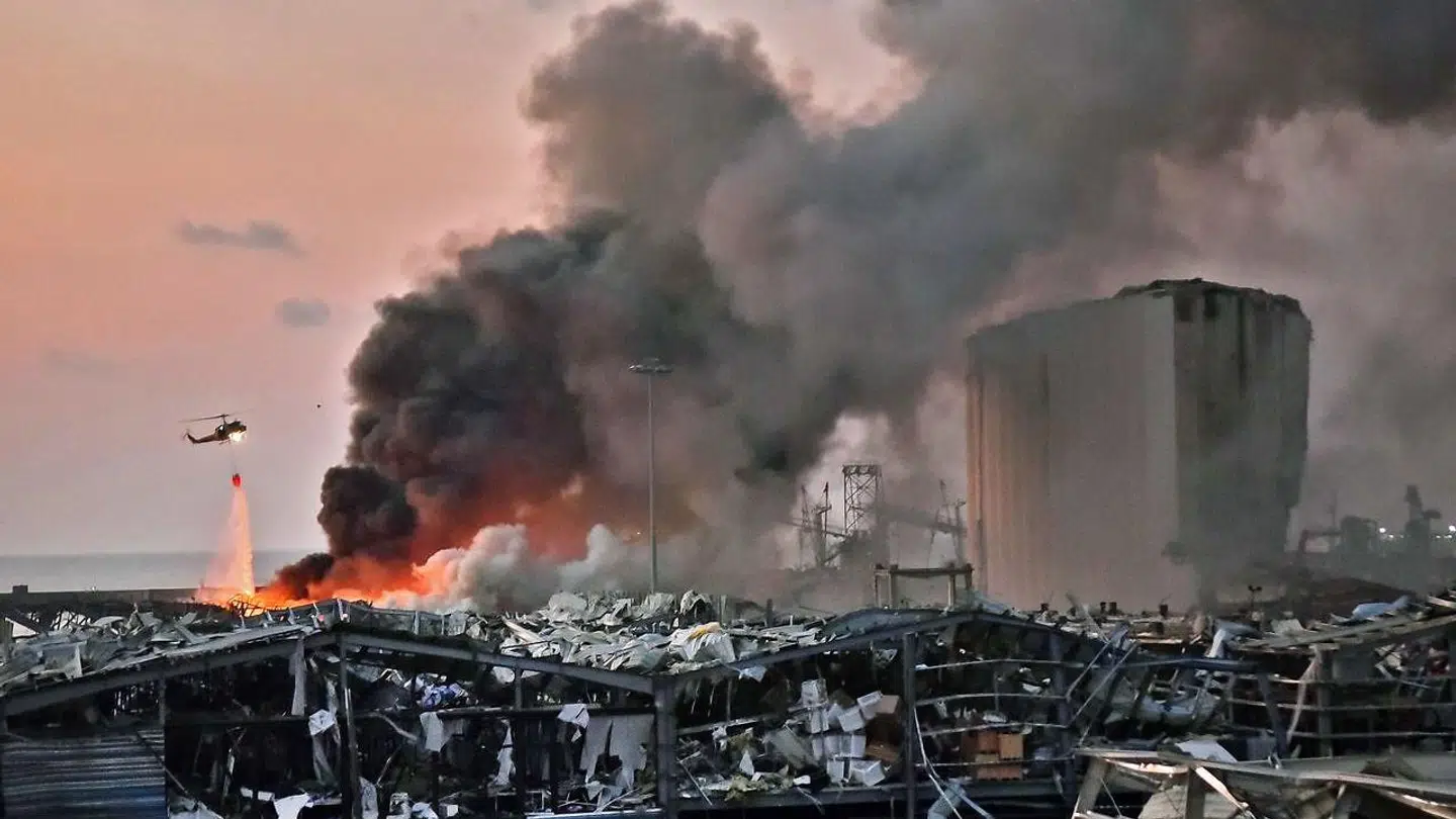 En helikopter i gang med slukningsarbejde på havnen i Beirut efter den voldsomme eksplosion 4. august 2020.
