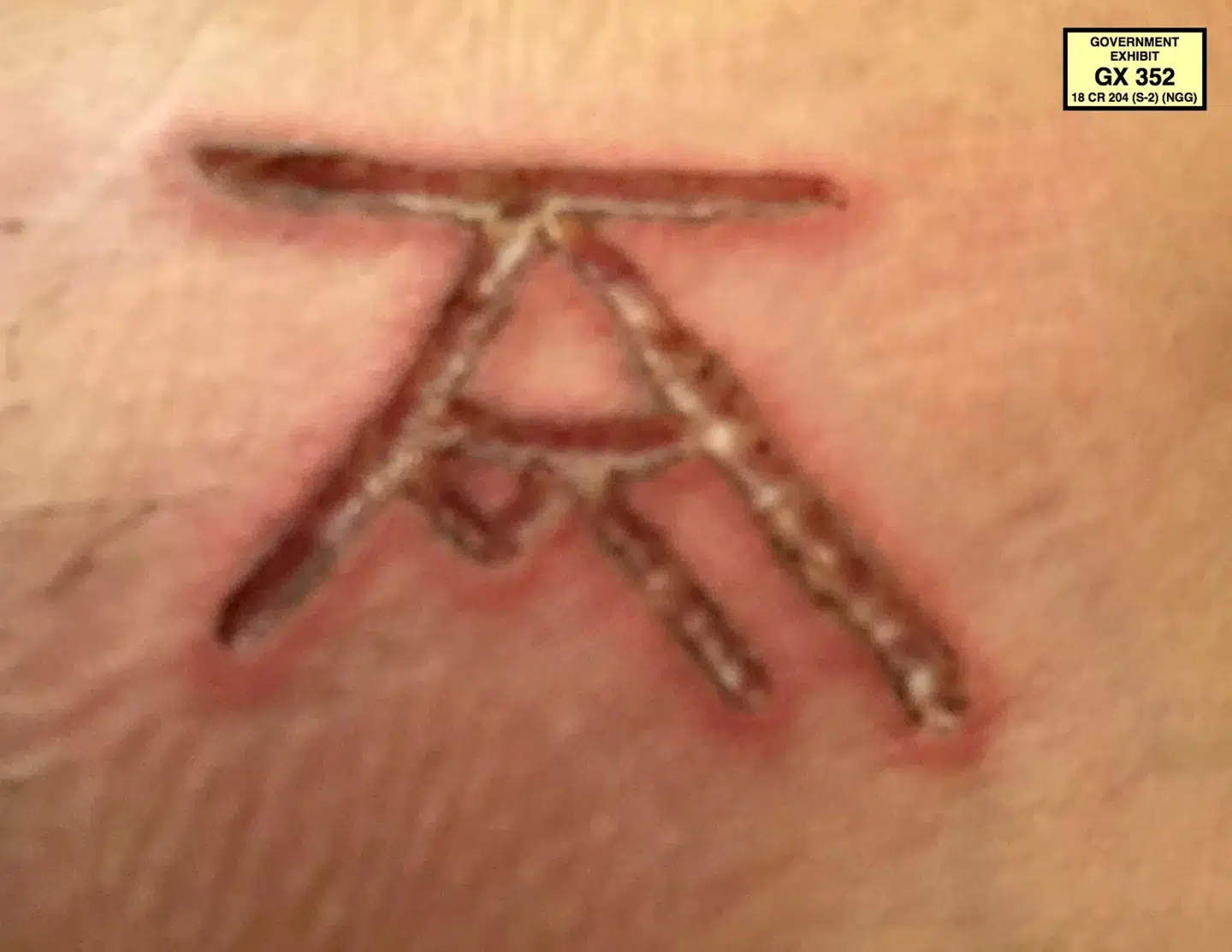 Dette tegn fik de udvalgte kvinder brændt ind i deres hud. Vender man det 90 grader, kan man se Keith Ranieres initialer.