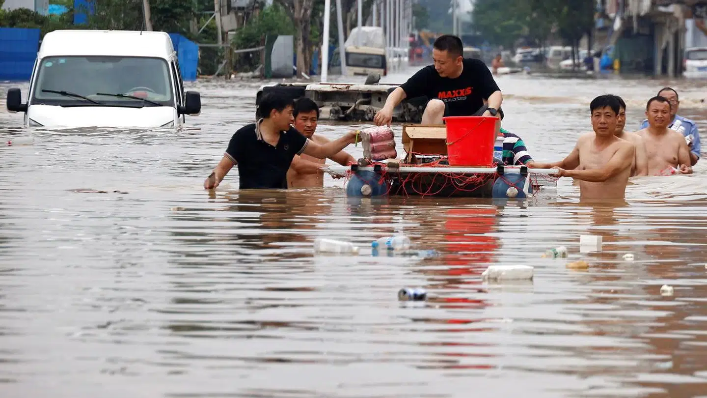 Folk står i vand til livet, mens de kæmper sig væk fra de oversvømmede områder.