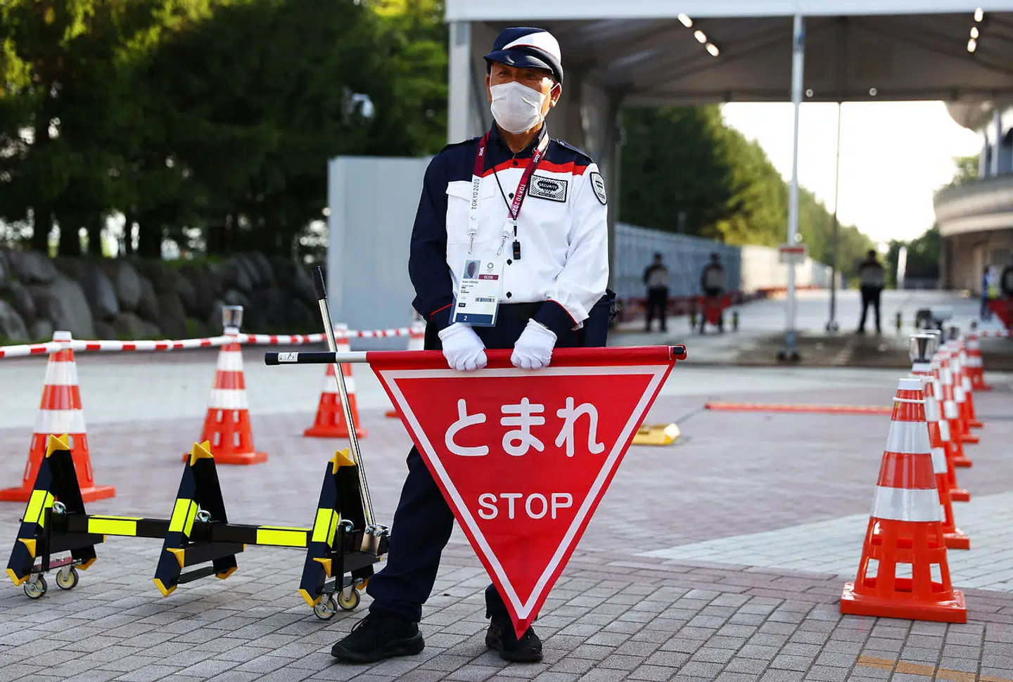 A security personnel stands with a stop sign at the Fukushima Azuma Baseball Stadium, ahead of the first event of the Tokyo 2020 Olympic Games, when Japan meets Australia in the opening round of the women's softball, in Fukushima, Japan July 21, 2021. REUTERS/Jorge Silva