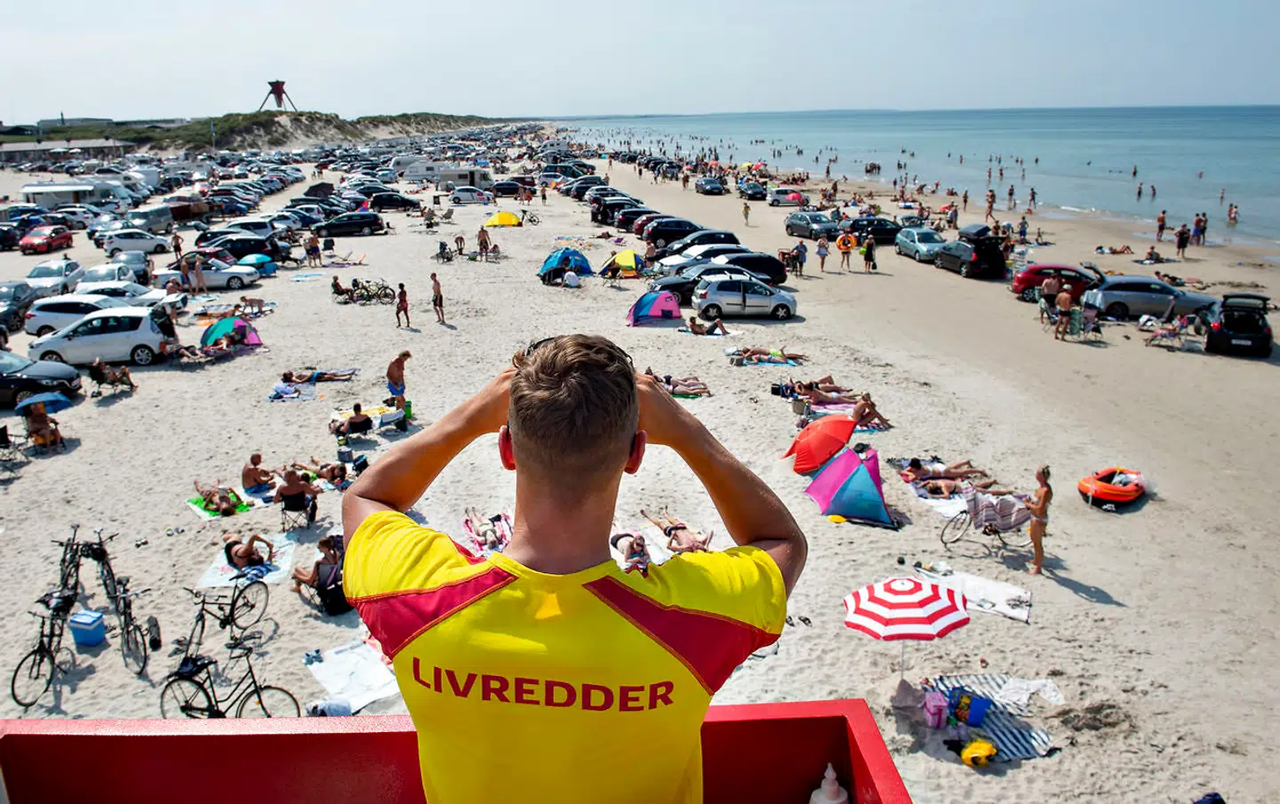 (ARKIV) En livredder fra Trygfonden holder øje med stranden der er pakket med biler og badende ved Blokhus i Nordjylland , torsdag den 25. juli 2019. Mette Frederiksen ønsker at øge danskernes forbrug med en såkaldt sommerpakke. Det er dog ikke nødvendigvis nu, krudtet skal bruges, mener forbrugerøkonom. Det skriver Ritzau, mandag den 8. juni 2020.. (Foto: Henning Bagger/Ritzau Scanpix)