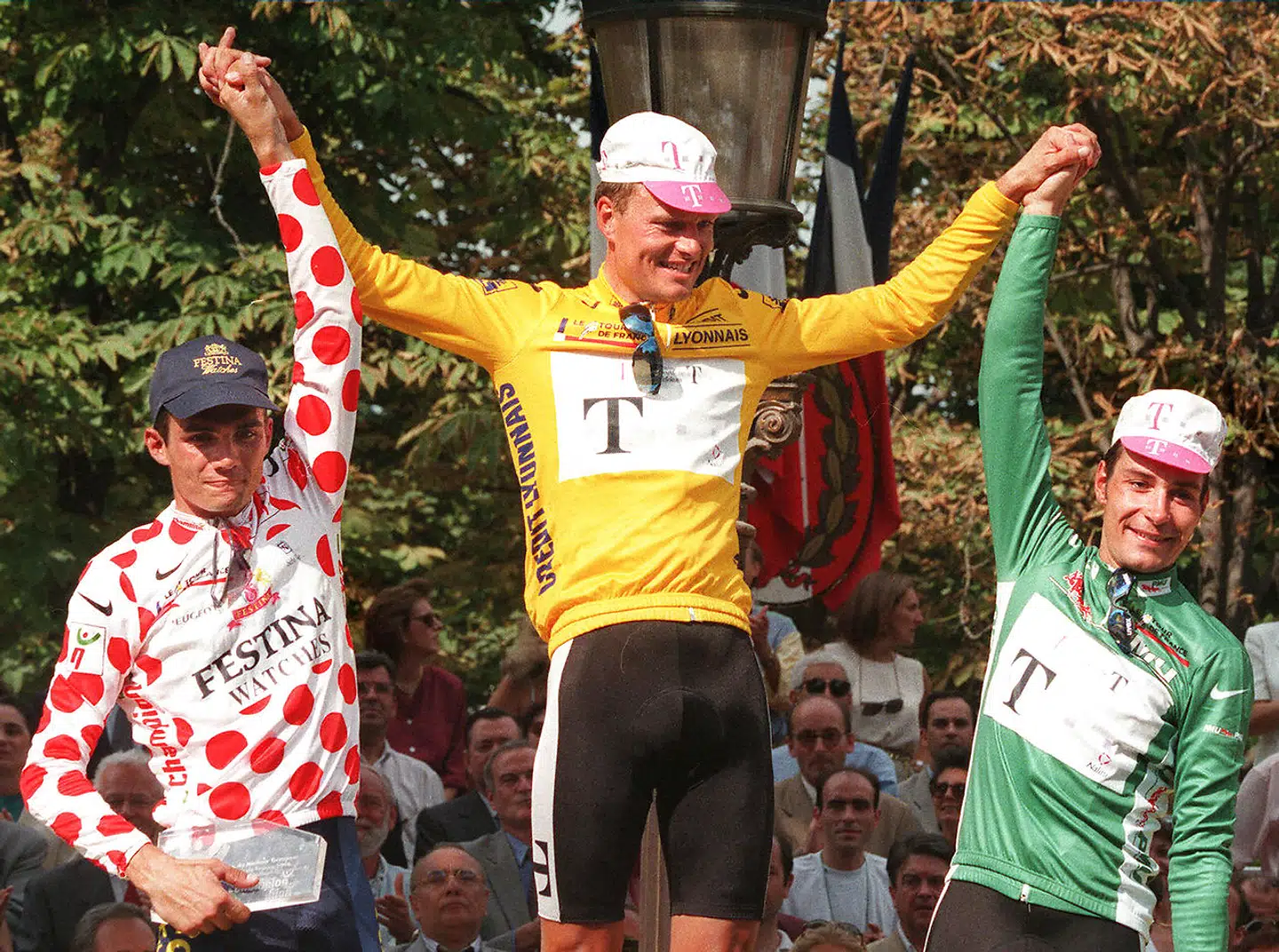 Bjarne Riis står i Paris som samlet vinder af Tour de France. Til venstre ses Richard Virenque i den prikkede bjergtrøje, og til højre står vinderen af pointtrøjen Erik Zabel.
