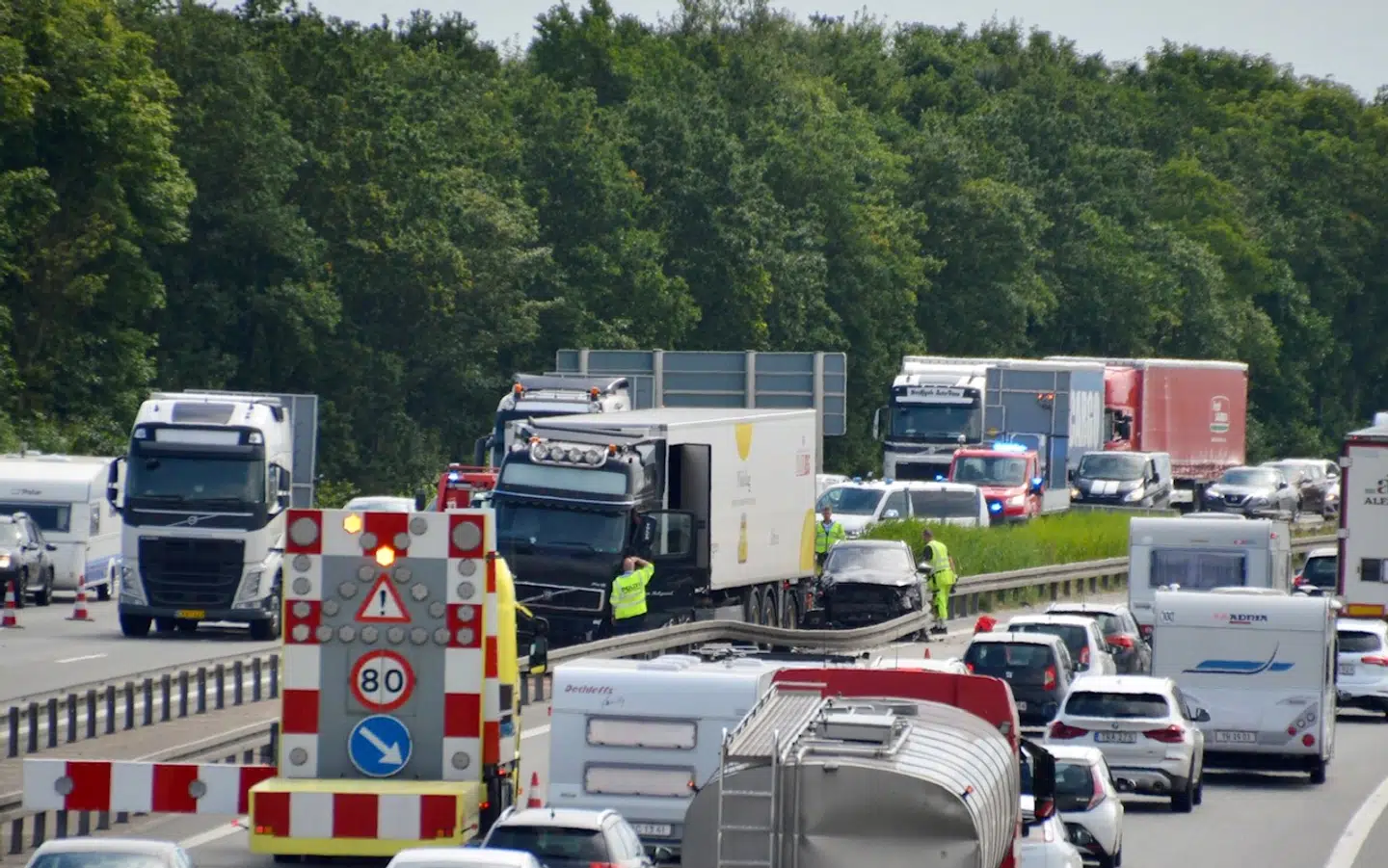 Lastbilen og personbilen står plantet i midterrabatten.