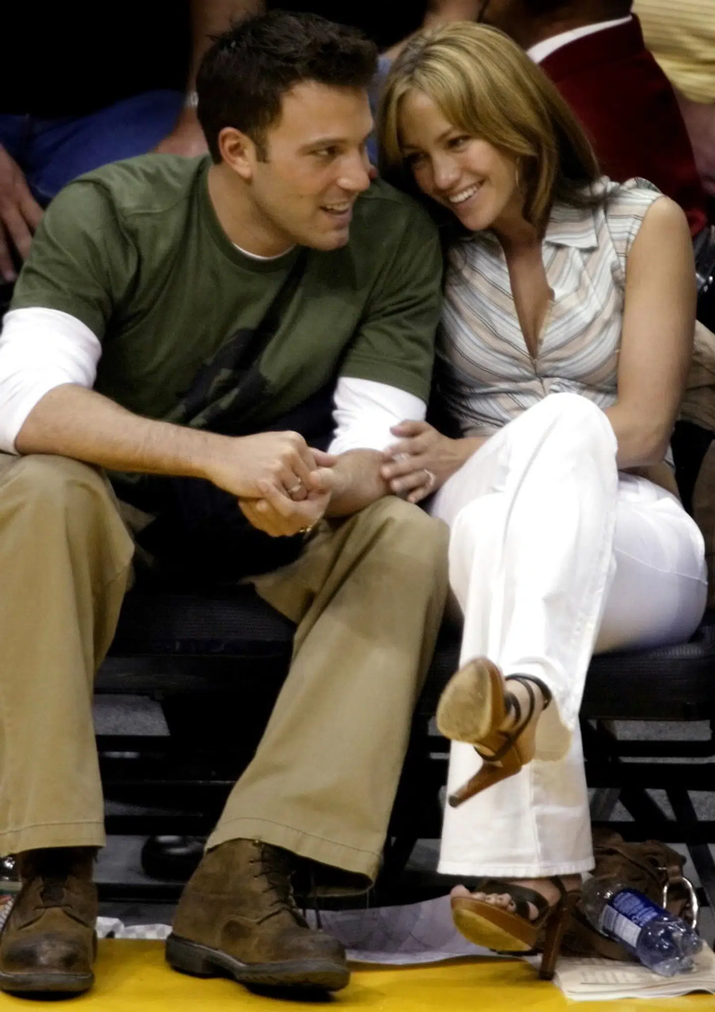 FILE PHOTO: Ben Affleck gets a smile from girlfriend Jennifer Lopez during the Los Angeles Lakers San Antonio Spurs NBA Western Conference semifinal in Los Angeles May 11, 2003. REUTERS/Mike Blake MB/File Photo
