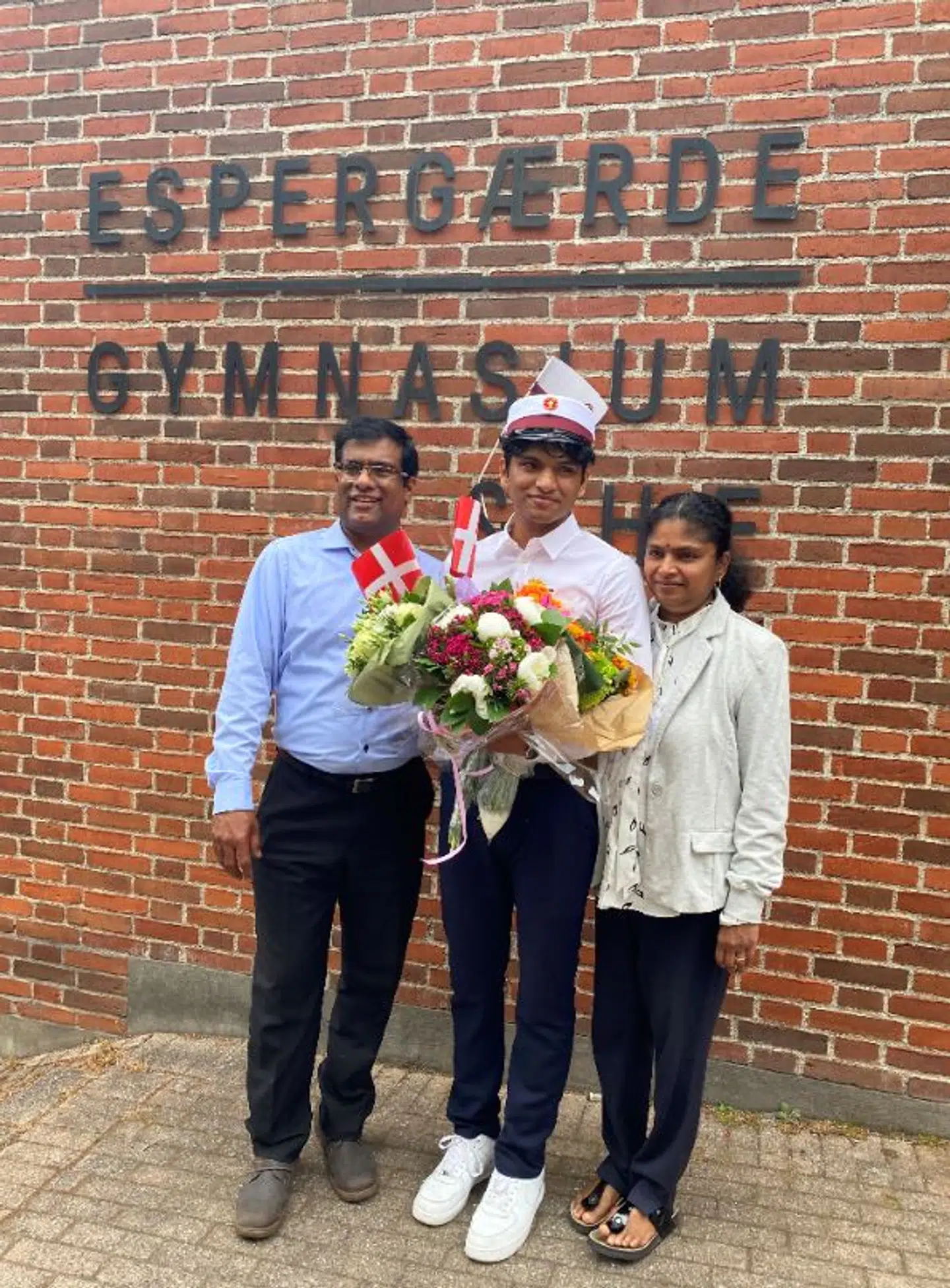Her står Raaman Krishnapillai sammen med sine forældre foran Espergærde Gymnasium. Privatfoto.